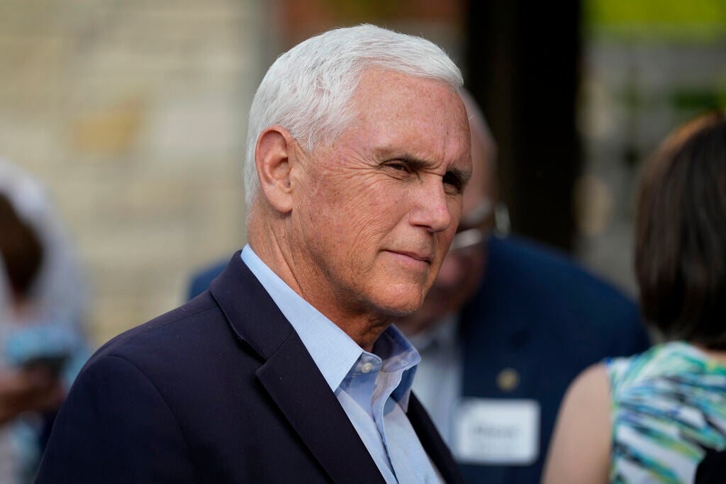 Former Vice President Mike Pence talks with local residents in Des Moines. Pence has filed paperwork declaring his campaign for president in 2024, setting up a historic challenge to his former boss, Donald Trump.     PHOTO CREDIT: Charlie Neibergall