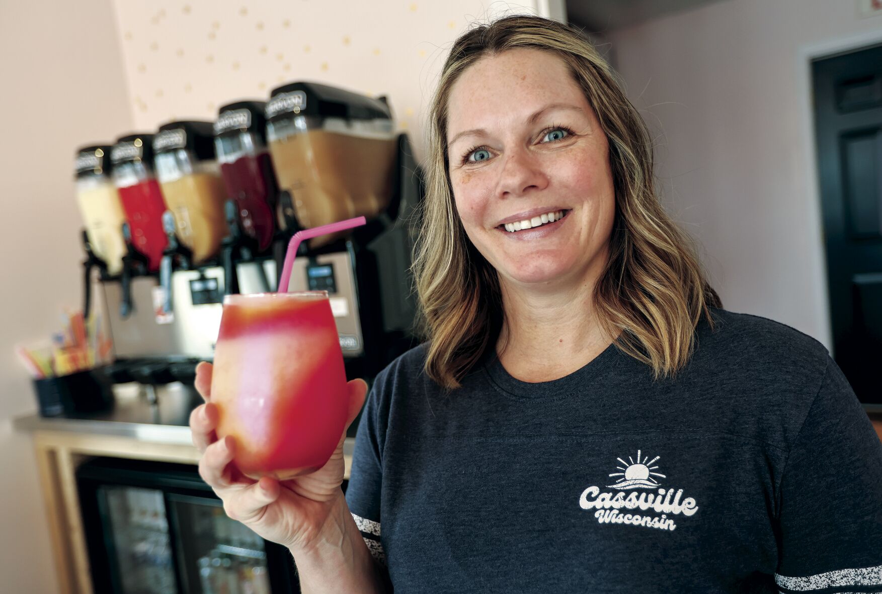 Owner of The Neighborhood Slush, Carrie Wunderlin, holds one of her wine slushy drinks at her business located in Cassville, Wis. The busines opened last month and plans a grand opening party on July 15.    PHOTO CREDIT: Dave Kettering