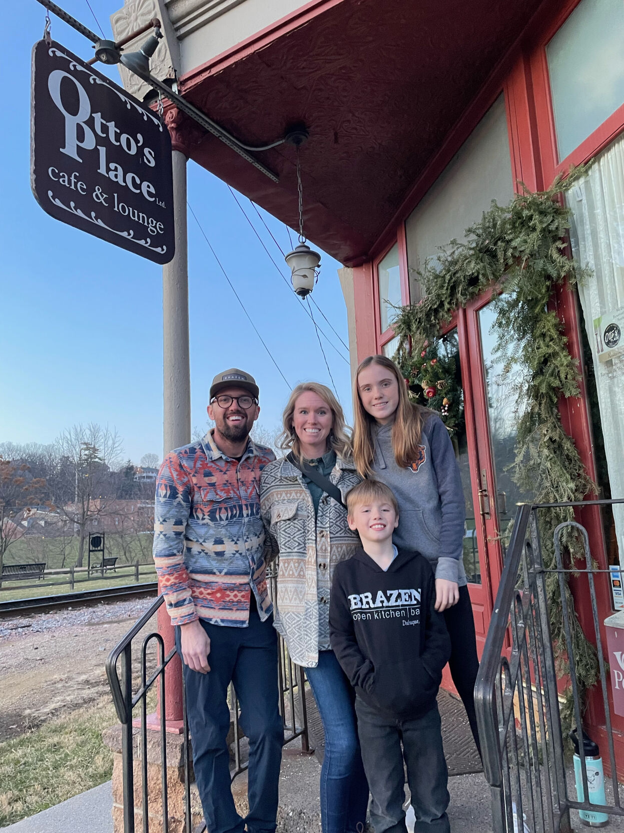 Kevin Scharpf, his wife Lyndsi Scharpf and their children Lloyd, 8, (in the front) and Lola, 10, stand in front of Galena restaurant Otto’s Place. The couple are the new owners of Otto’s Place — Kevin is chef and owner at Brazen Kitchen + Bar in Dubuque.    PHOTO CREDIT: Contributed