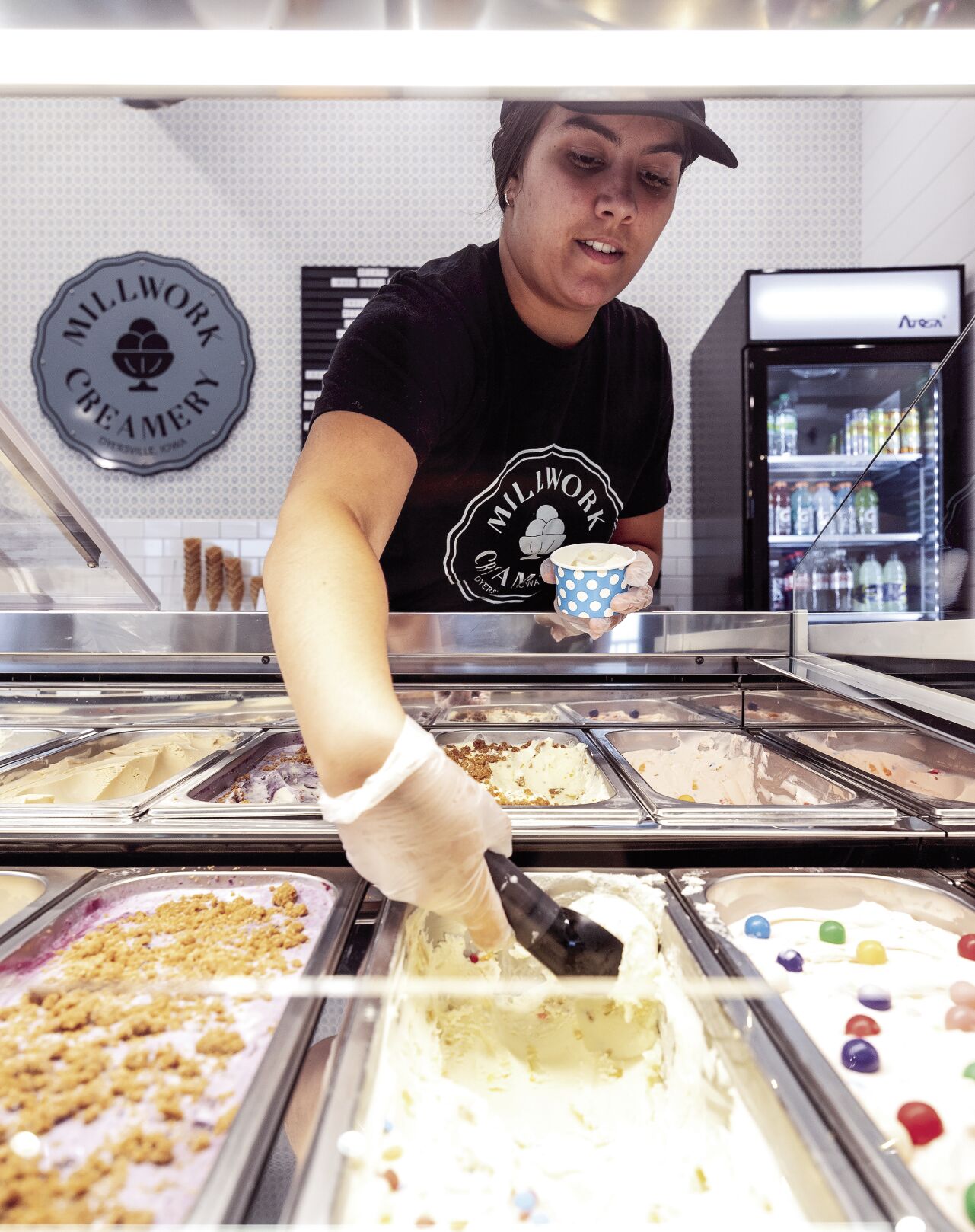 Teresa Braun scoops ice cream at Millwork Creamery in Dyersville, Iowa on Friday.    PHOTO CREDIT: Stephen Gassman