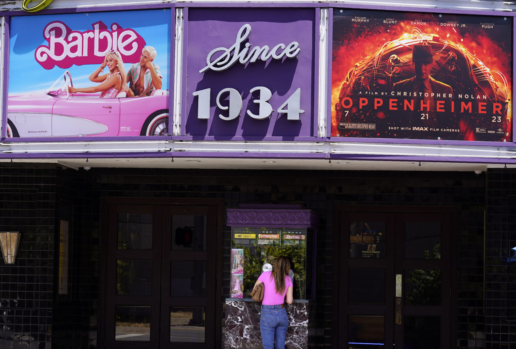 <p>A patron buys a movie ticket underneath a marquee featuring the films "Barbie" and "Oppenheimer" at the Los Feliz Theatre, Friday, July 28, 2023, in Los Angeles. (AP Photo/Chris Pizzello)</p>   PHOTO CREDIT: Chris Pizzello 