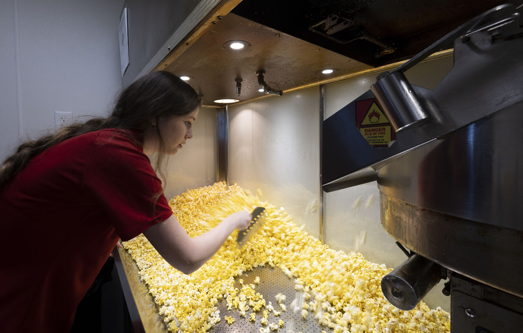 Supervisor Sydney Schmitt scoops popcorn at Phoenix Theatres in Dubuque.    PHOTO CREDIT: Stephen Gassman
Telegraph Herald