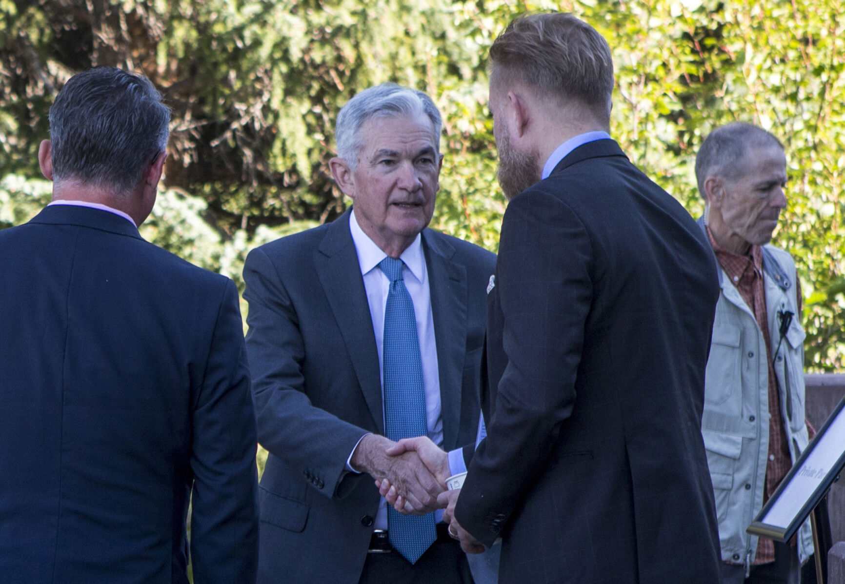 <p>File - Federal Reserve Chair Jerome Powell, center, shakes hands with Asgeir Jonsson, governor of the Central Bank of Iceland, at the annual Jackson Hole Economic Policy symposium in Grand Teton National Park in Moran, WY. on Aug. 26, 2022. When Powell delivers a high-profile speech Friday in Jackson Hole, many analysts think he could make one thing clear: That the Fed plans to keep its benchmark interest rate at a peak level for longer than had been expected. (AP Photo/Amber Baesler, File)</p>   PHOTO CREDIT: Amber Baesler - freelancer, ASSOCIATED PRESS
