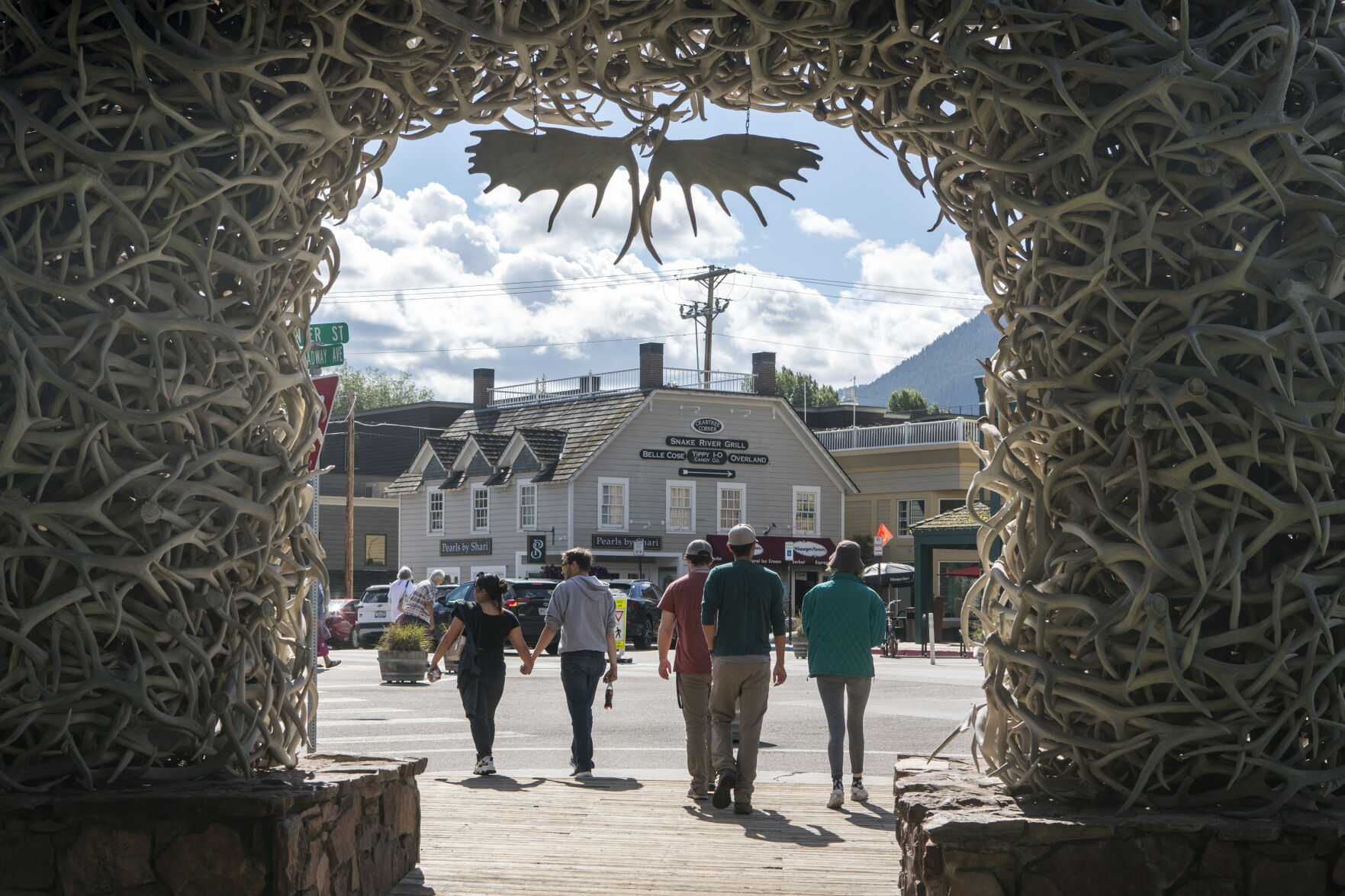 <p>Tourists walk around Town Square in Jackson, Wyo. on Aug. 23, 2023. When Federal Reserve Chair Jerome Powell delivers a high-profile speech Friday in Jackson Hole, many analysts think he could make one thing clear: That the Fed plans to keep its benchmark interest rate at a peak level for longer than had been expected. (AP Photo/Amber Baesler)</p>   PHOTO CREDIT: Amber Baesler - freelancer, ASSOCIATED PRESS