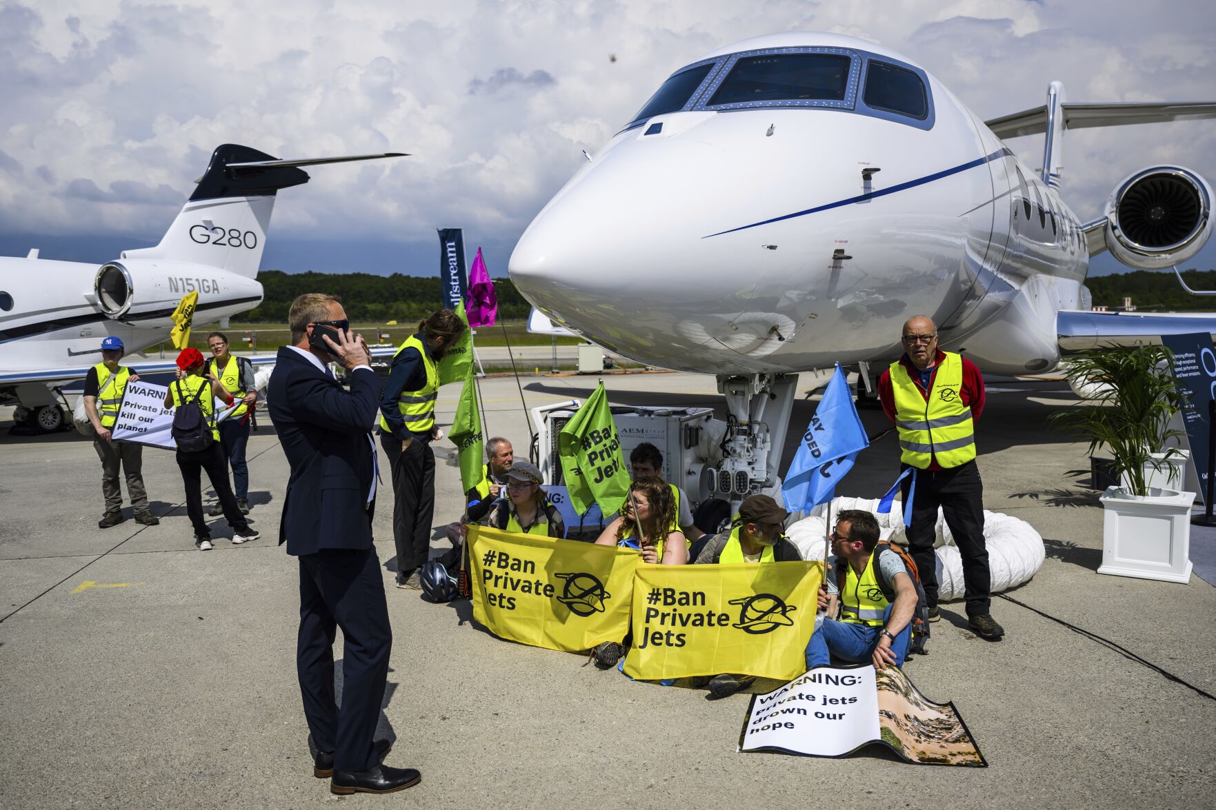 <p>FILE - Environmental activists of Stay Grounded and Greenpeace demonstrate while handcuffing themselves to a plane during the European Business Aviation Convention and Exhibition (EBACE), at the Geneve Aeroport in Geneva, Switzerland, May 23, 2023. Climate activists have spraypainted a superyacht, blocked private jets from taking off and plugged holes in golf courses this summer as part of an intensifying campaign against the emissions-spewing lifestyles of the ultrawealthy. (Laurent Gillieron/Keystone via AP, File)</p>   PHOTO CREDIT: LAURENT GILLIERON 