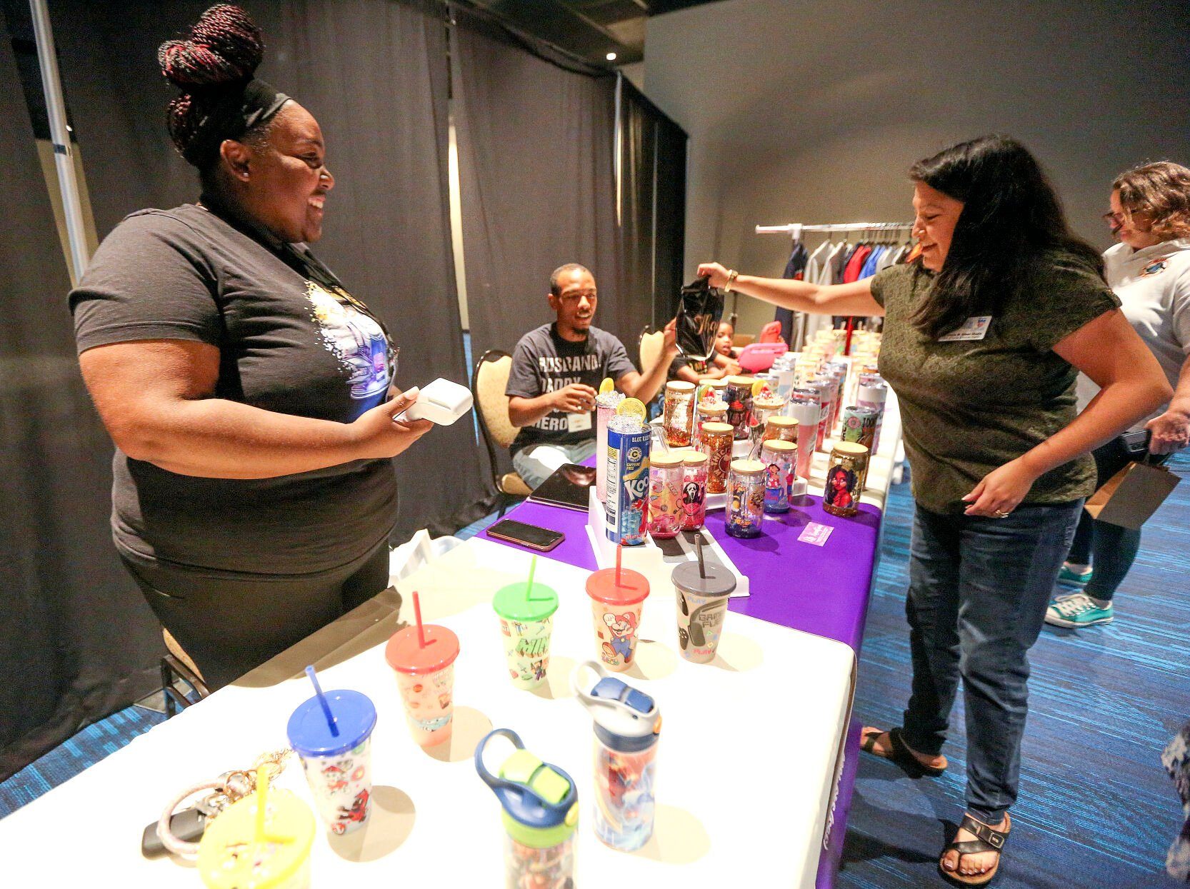 Chief of Equity and Human Rights for the City of Dubuque, Dr. Gisella Aitken-Shadle (right), talks with Tika Sykes, owner of KLS Kreation, during the third annual Black Business Expo held at the Q Casino.    PHOTO CREDIT: Dave Kettering