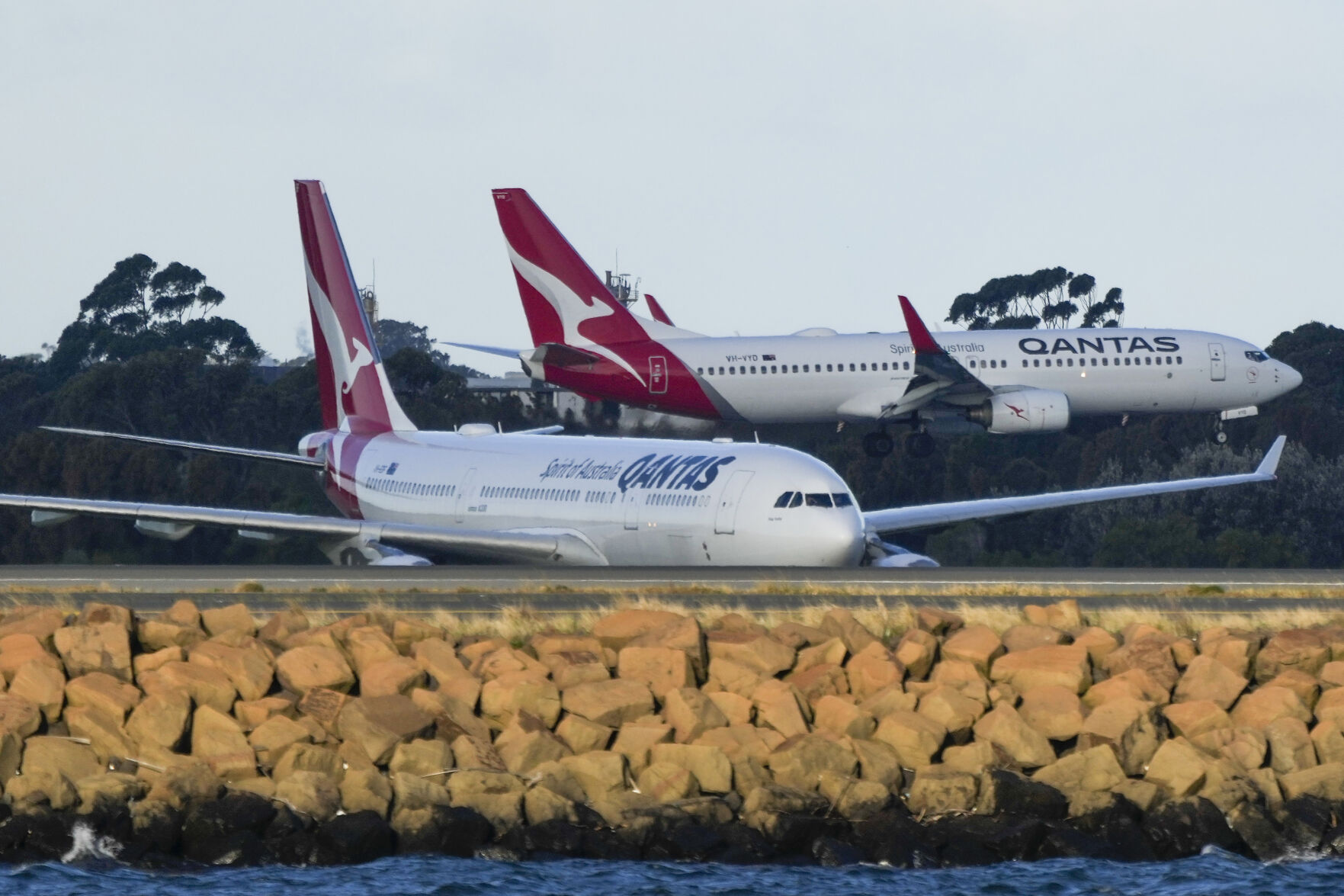<p>FILE - Qantas passenger jets cross as they taxi at Sydney Airport in Sydney, Australia, on Sept. 5, 2022. Australia’s consumer watchdog on Friday, Sept. 1, 2023, called for Qantas Airways to be punished with a record fine for allegedly selling tickets on thousands of flights that had already been canceled. (AP Photo/Mark Baker,File)</p>   PHOTO CREDIT: Mark Baker 