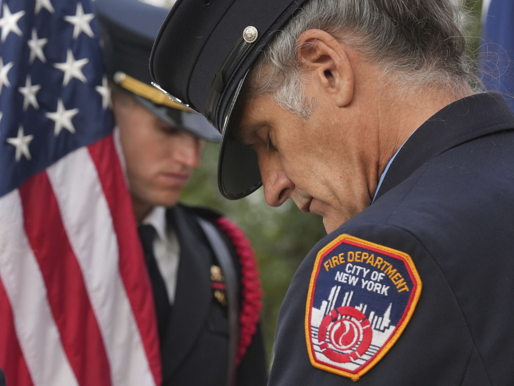 Retired New York City firefighter Paul Matulis (right) and Austin firefighter Matthew Boyan, of the Austin Fire Department Honor Guard, pray during a 9/11 Memorial at the Buford Fire Tower in Austin, Texas, on Monday.    PHOTO CREDIT: Jay Janner