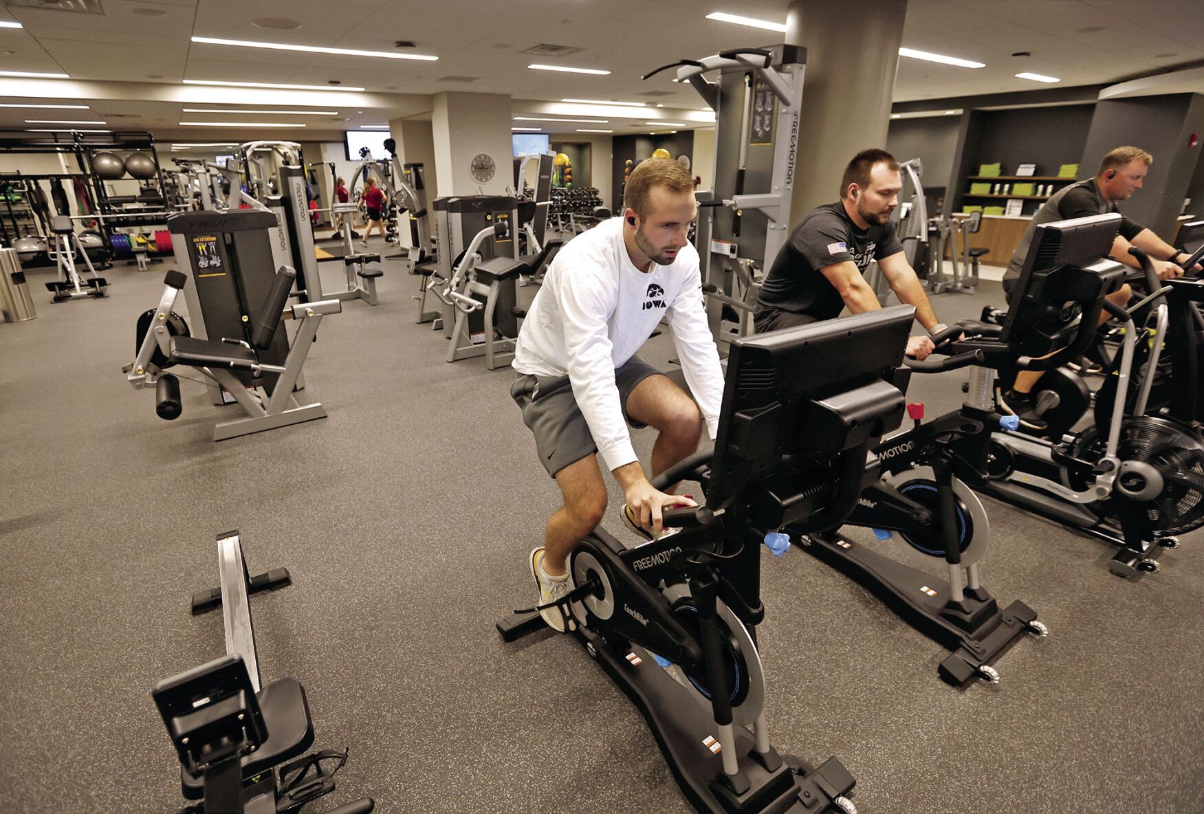 Brock Hillers (from left), Kyle Cluskey and Aaron Wulfekuhle, all employees with Cottingham & Butler, workout in a fitness center shared by Cottingham & Butler and HTLF at the Roshek Building in Dubuque on Tuesday, Sept. 26, 2023.    PHOTO CREDIT: JESSICA REILLY