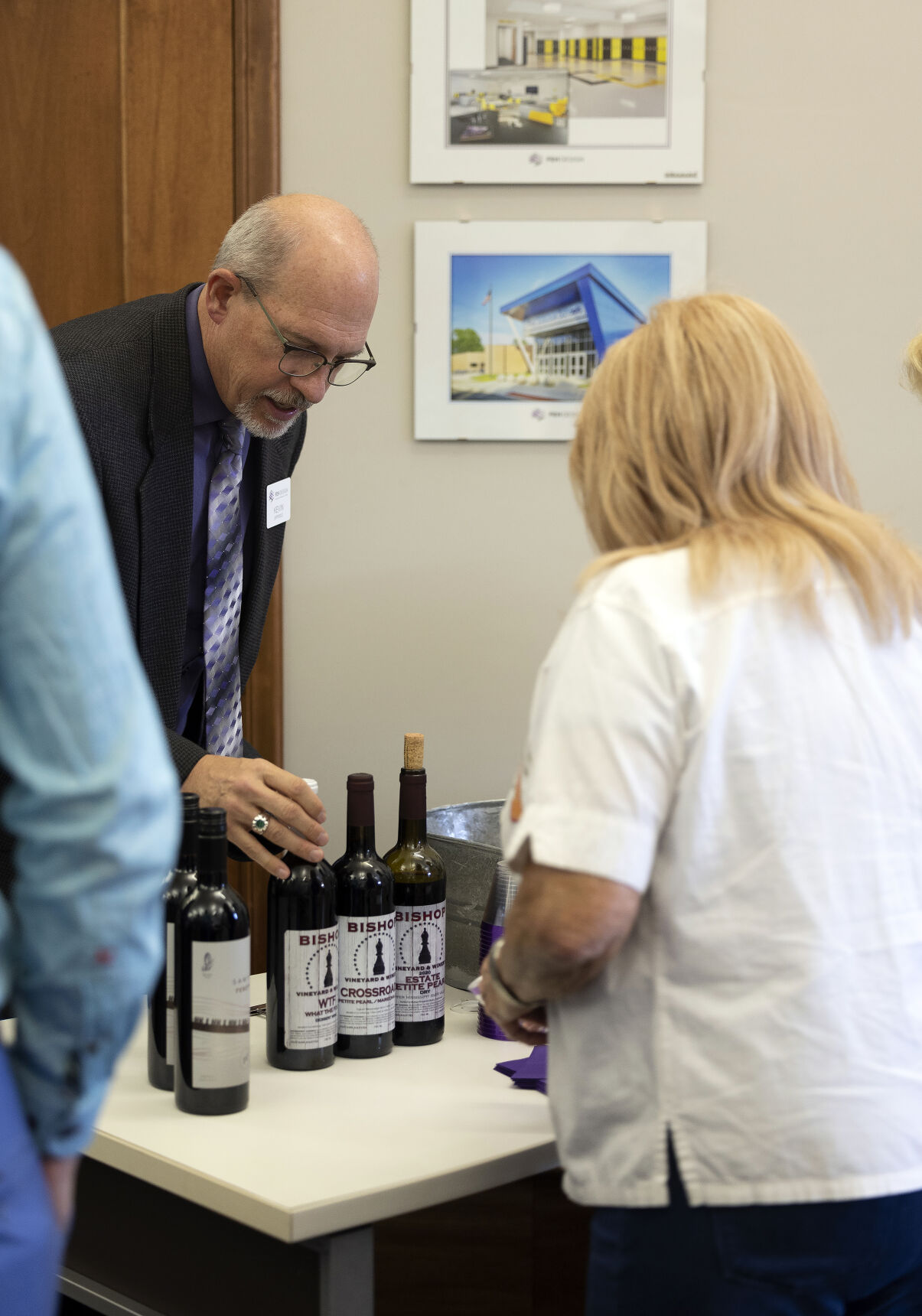 Kevin Eipperle with FEH Design in Dubuque helps with a wine selection.    PHOTO CREDIT: Stephen Gassman