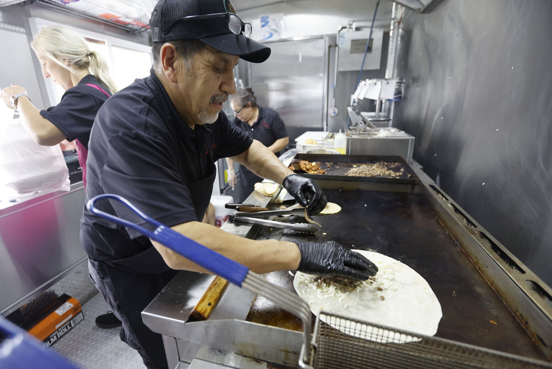 Mario Pulido prepares food at Pulido