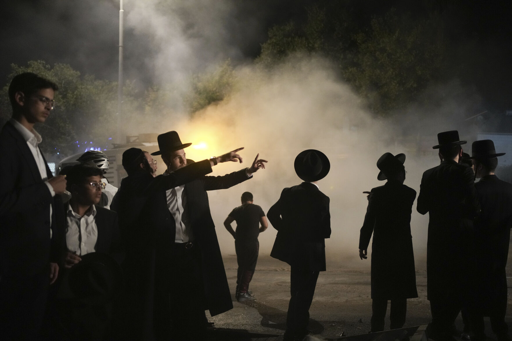 <p>Ultra-Orthodox Jewish men inspect a damaged road after it was hit by a rocket fired from the Gaza Strip, in the West Bank Jewish settlement of Beitar Illit, Monday, Oct. 9, 2023. (AP Photo/Maya Alleruzzo)</p>   PHOTO CREDIT: Maya Alleruzzo - staff, ASSOCIATED PRESS