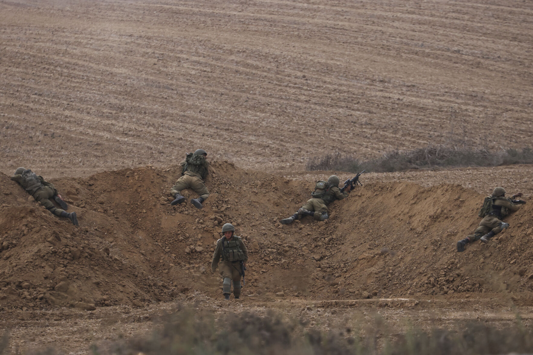 <p>Israeli soldiers take position near the Israeli Gaza border, southern Israel, Monday, Oct. 9, 2023. The militant Hamas rulers of the Gaza Strip carried out an unprecedented, multi-front attack on Israel at daybreak Saturday, firing thousands of rockets as dozens of Hamas fighters infiltrated the heavily fortified border in several locations, killing hundreds and taking captives. Palestinian health officials reported scores of deaths from Israeli airstrikes in Gaza. (AP Photo/Oren Ziv)</p>   PHOTO CREDIT: Oren Ziv - staff, ASSOCIATED PRESS