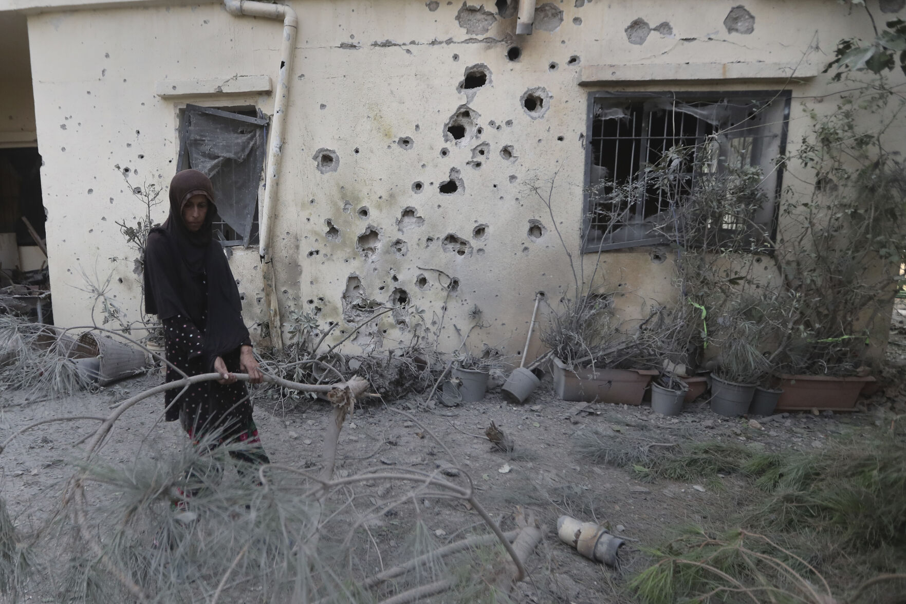 <p>A Lebanese woman removes broken tree branches after her house was hit by Israeli shelling, in Dahaira village, South Lebanon, Monday, Oct. 9, 2023. Israeli troops shot and killed several gunmen who crossed into the country from Lebanon, the Israeli Defense Forces said, without specifying the number of people killed nor their alleged affiliation. (AP Photo/Mohammed Zaatari)</p>   PHOTO CREDIT: Mohammed Zaatari - stringer, ASSOCIATED PRESS