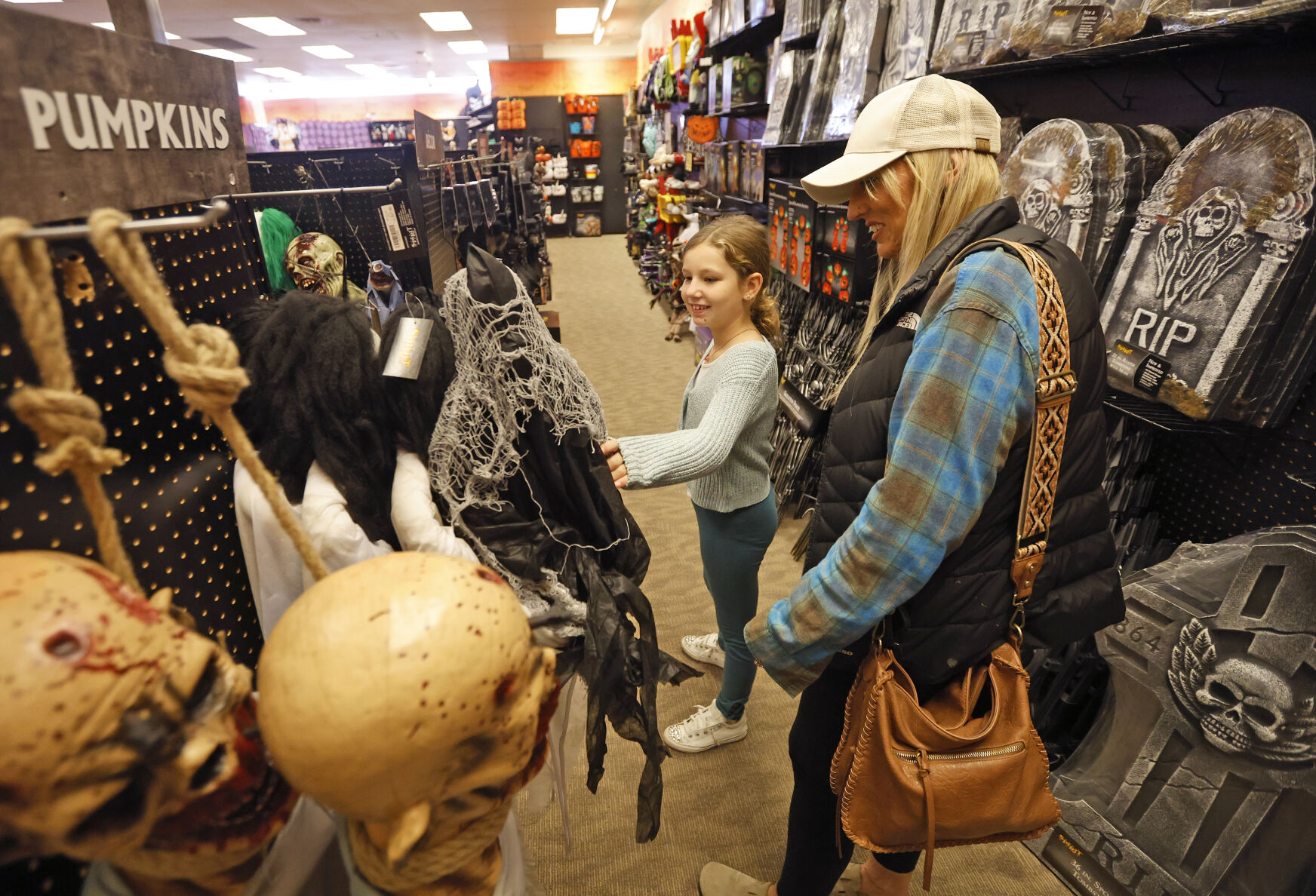 Christine Wilson and Gemma Oberbroeckling, 8, both of Bellevue, Iowa, browse costumes at Spirit Halloween in Dubuque on Tuesday.    PHOTO CREDIT: JESSICA REILLY