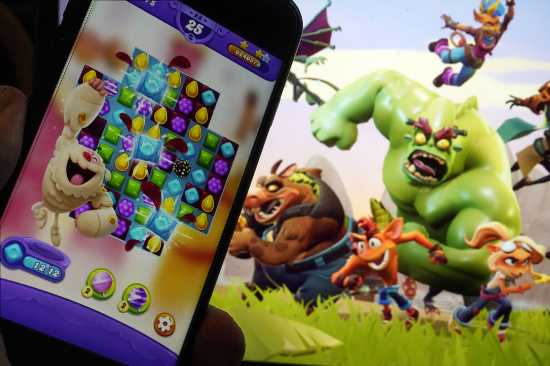 <p>Scenes from "Candy Crush Saga," left, by Activision Blizzard, and "Crash Team Rumble," from Activision Publishing, are shown in this photo, in New York, Wednesday, June 21, 2023. Microsoft’s purchase of video game maker Activision Blizzard won final approval Friday, Oct. 13, from Britain’s competition watchdog, reversing its earlier decision to block the $69 billion deal and removing a last obstacle for one of the largest tech transactions in history. (AP Photo/Richard Drew)</p>   PHOTO CREDIT: Richard Drew - staff, ASSOCIATED PRESS