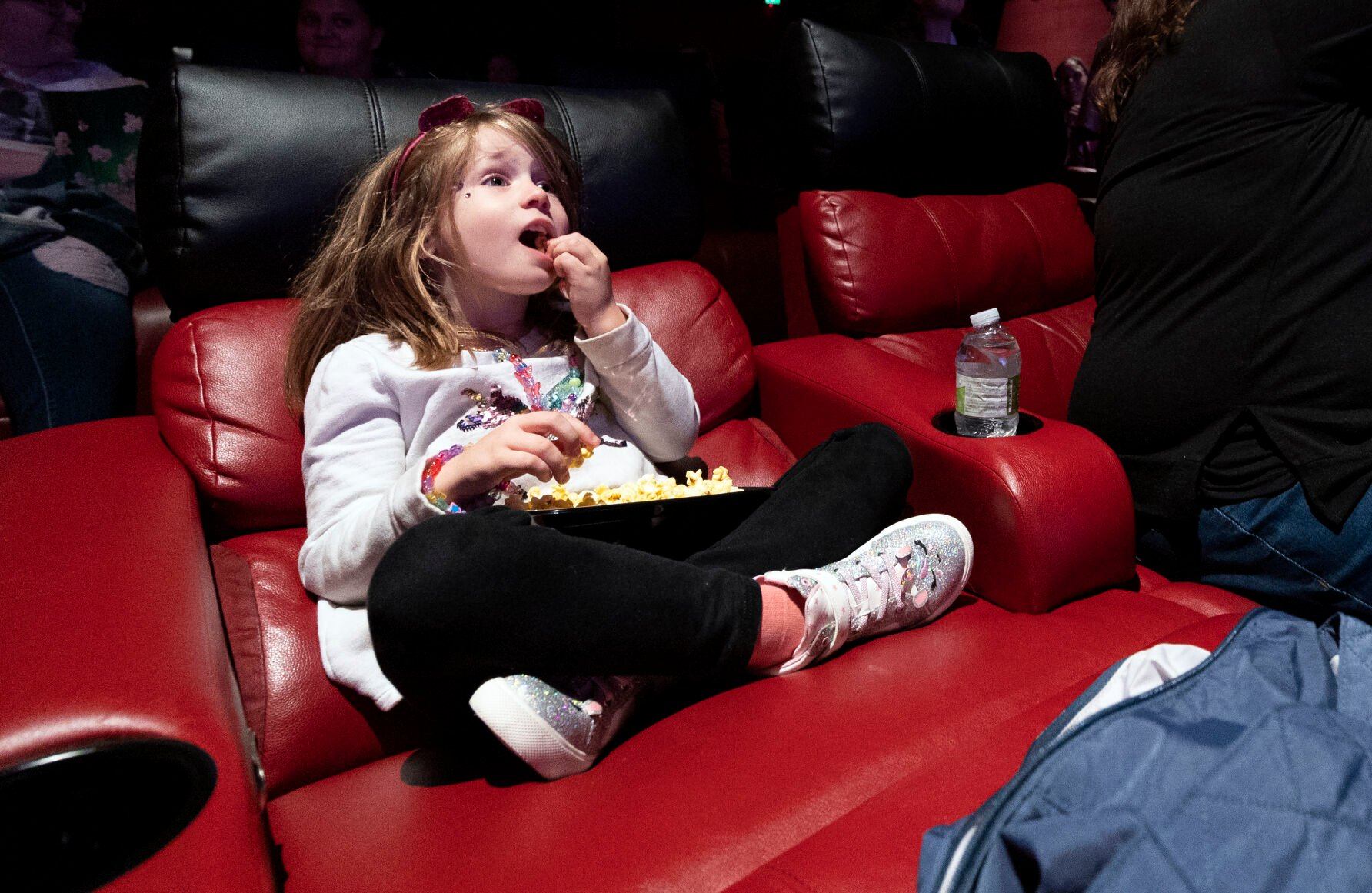 Elena Enzler, 5, enjoys the start of the “Taylor Swift: The Eras Tour” concert film at Phoenix Theatres in Dubuque on Saturday, Oct. 14, 2023.    PHOTO CREDIT: Gassman