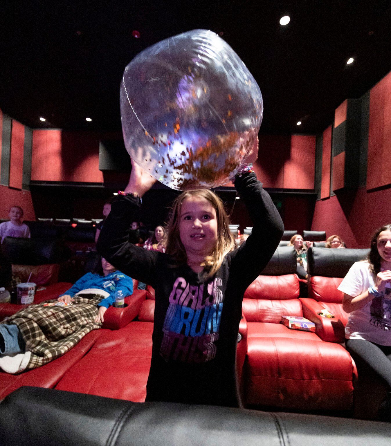 Josephine Enzler, 7, tosses a beach ball before the “Taylor Swift: The Eras Tour” concert film at Phoenix Theatres in Dubuque on Saturday, Oct. 14, 2023.    PHOTO CREDIT: Stephen Gassman
