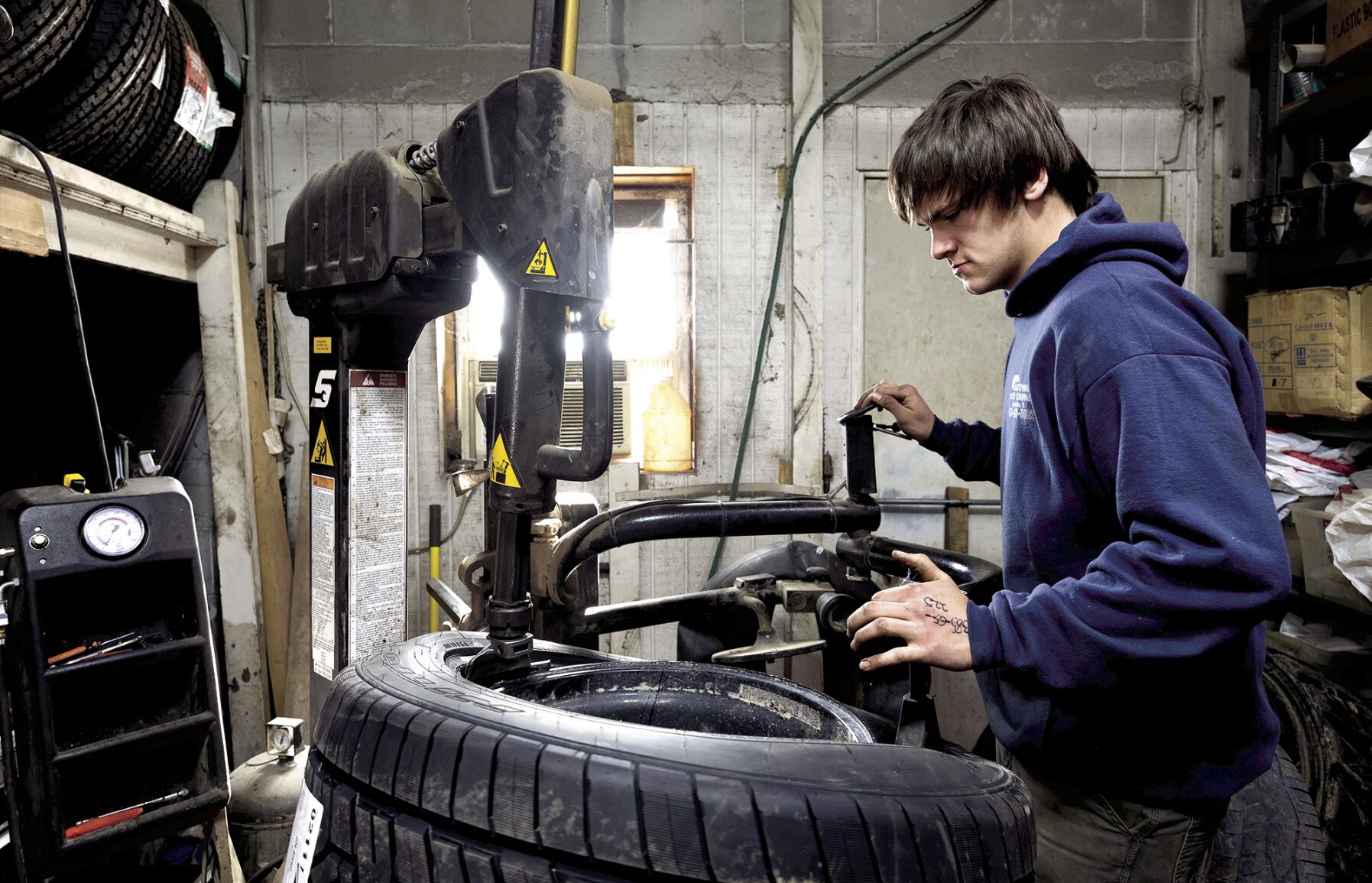 Owner Jack Kremer works on a tire at Kremer Tire & Auto in La Motte, Iowa, on Thursday.    PHOTO CREDIT: Stephen Gassman