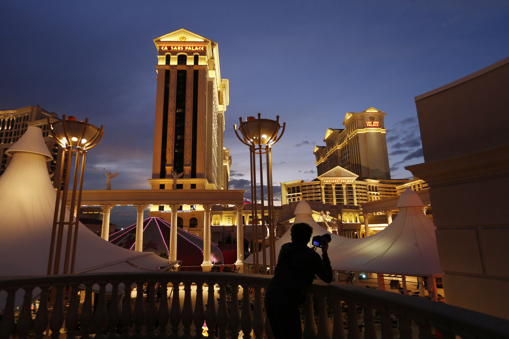 <p>FILE - A man takes pictures of Caesars Palace hotel and casino in Las Vegas, Jan. 12, 2015. The Culinary Workers Union in Las Vegas has reached a tentative deal with casino giant Caesars Entertainment that could help avert a sweeping strike. The deal announced early Wednesday, Nov. 8, 2023, marks a major breakthrough after several months of unsuccessful negotiations. (AP Photo/John Locher, File)</p>   PHOTO CREDIT: John Locher 