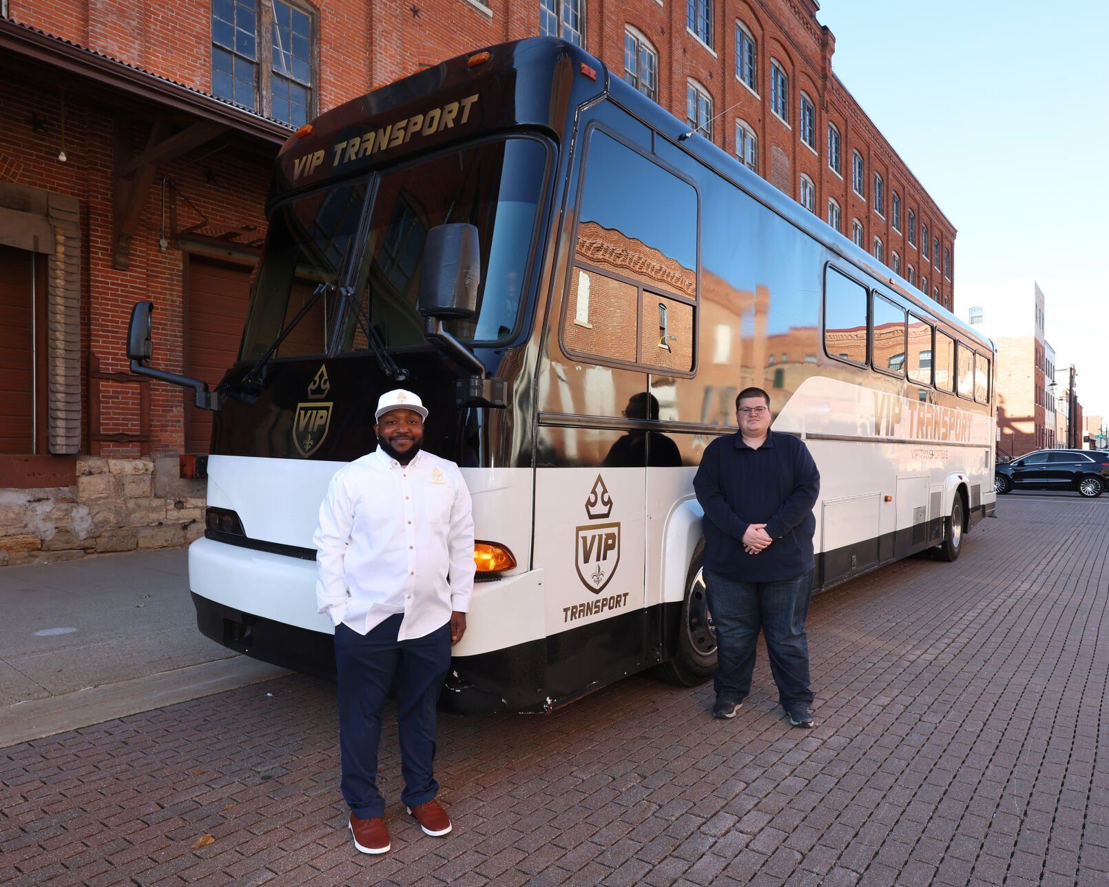 VIP Transport owners Dionte Stewart (left) and Ryan Elliott outside their bus in Dubuque on Thursday, Nov. 9, 2023.    PHOTO CREDIT: Stephen Gassman