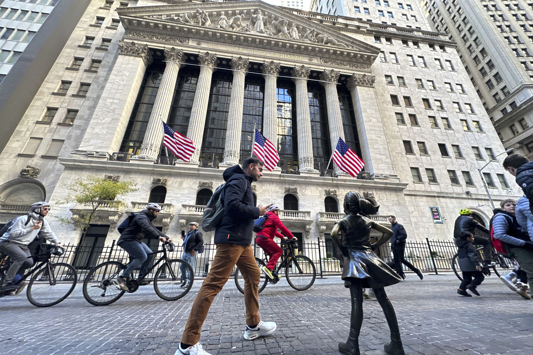 A man passes the "Fearless Girl" statue in front of the New York Stock Exchange in New York on Friday, November 3, 2023. (AP Photo/Ted Shaffrey)    PHOTO CREDIT: Associated Press