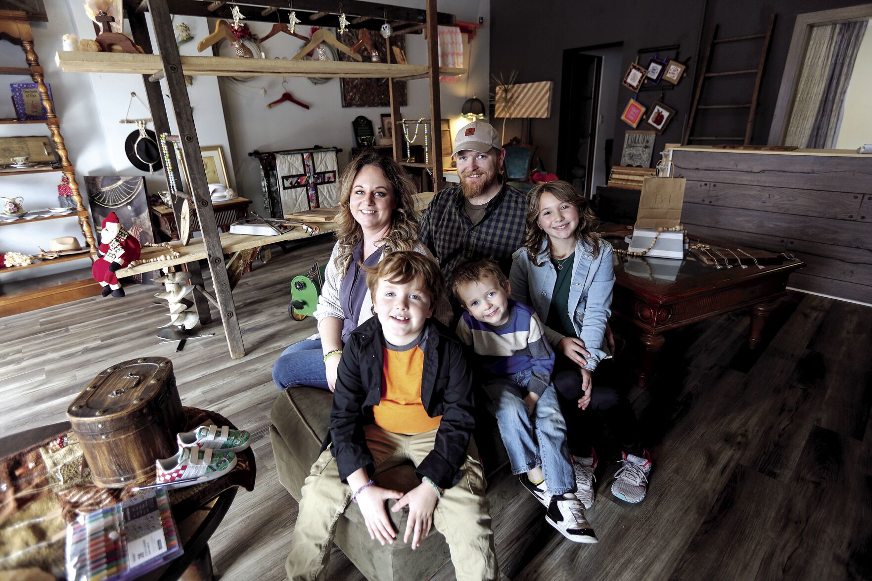 Ron Butler and his wife, Elizabeth, along with their children (from left) Henry, 7, Beau, 4, and Lillian, 11, sit inside their store, Butler Homestead, located at 1500 Central Ave. in Dubuque on Friday.    PHOTO CREDIT: Dave Kettering
