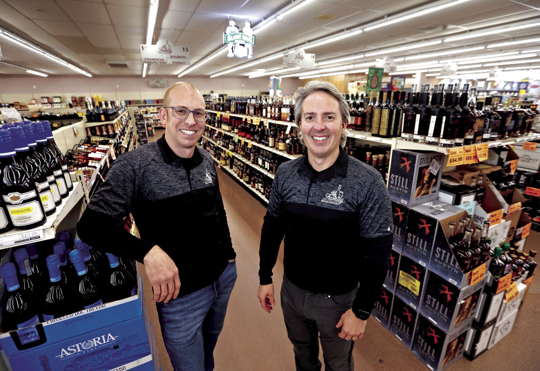 Josh Althaus (left) and Tim Althaus stand at Family Beer & Liquor in East Dubuque, Ill., on Tuesday. Tim, who has owned the store since 1999, is selling the business to Josh, his cousin.    PHOTO CREDIT: JESSICA REILLY