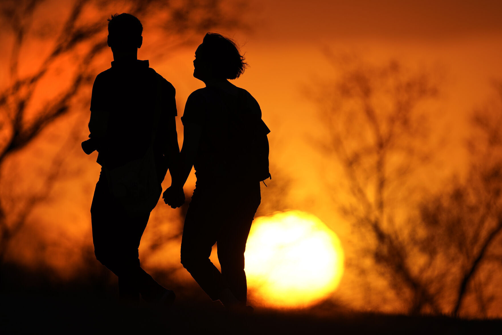 <p>FILE - A couple walks through a park at sunset, March 10, 2021, in Kansas City, Mo. U.S. life expectancy rose in 2022 — by more than a year — after plunging two straight years at the beginning of the COVID-19 pandemic, according to a new government report released Wednesday, Nov. 29, 2023. The rise was mainly due to the waning of the pandemic in 2022, researchers said at the Centers for Disease Control and Prevention. (AP Photo/Charlie Riedel, File)</p>   PHOTO CREDIT: Charlie Riedel 