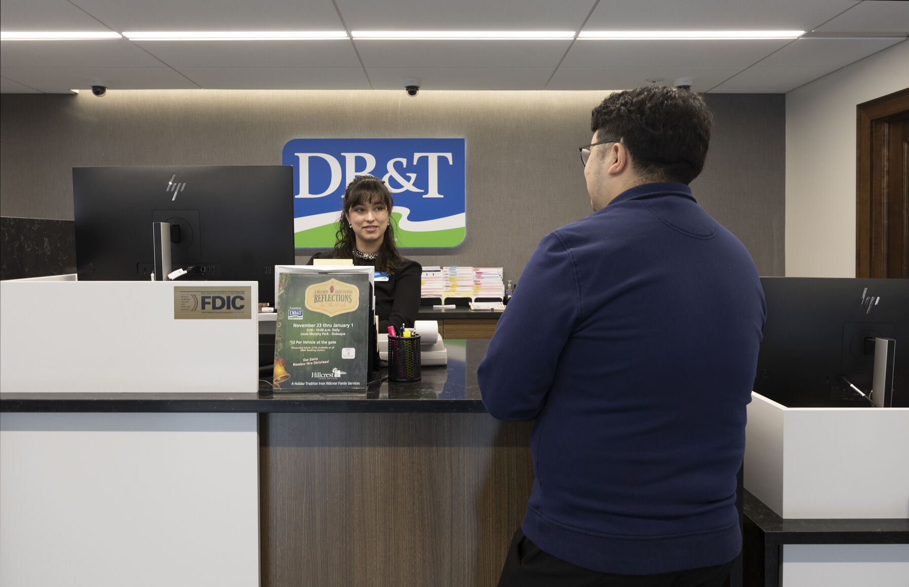 Universal Banker Rose Montieth helps a customer at the new Dubuque Bank & Trust location inside the Roshek Building on Locust Street in Dubuque on Monday.    PHOTO CREDIT: Stephen Gassman