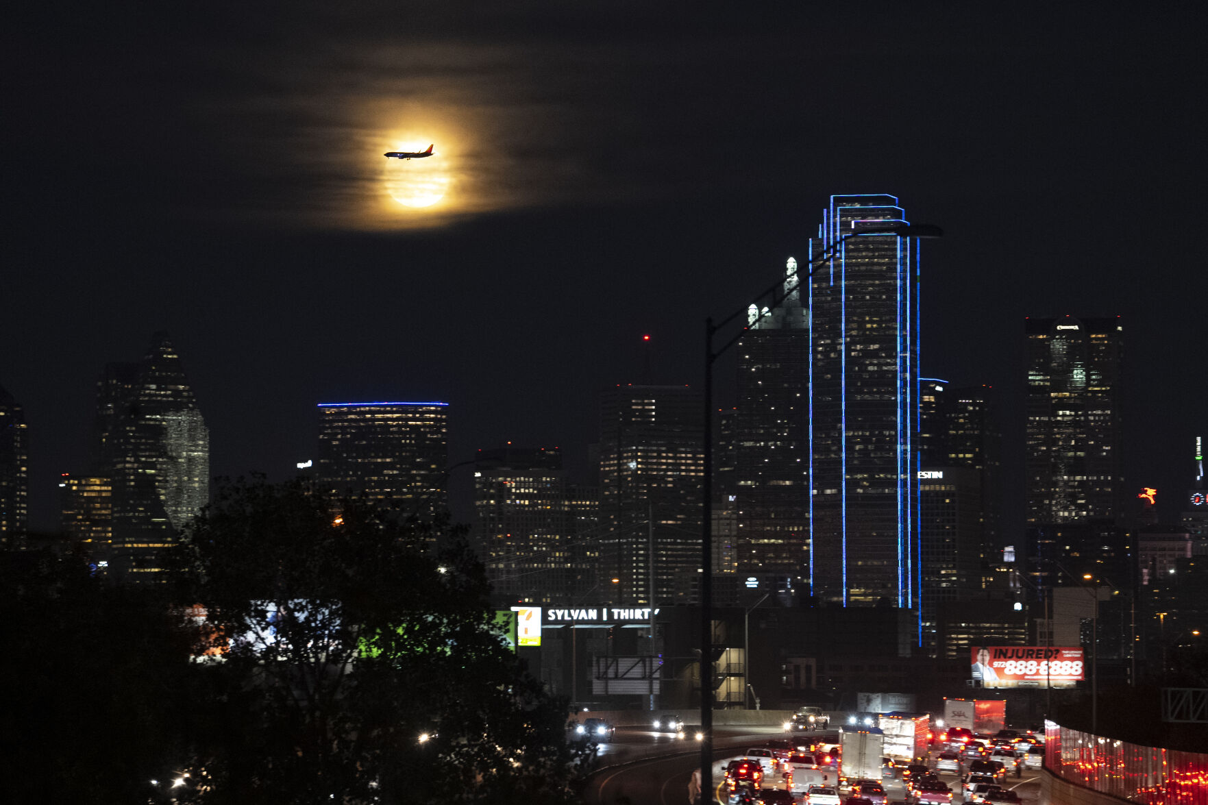 <p>A Southwest Airlines plane makes its final approach at Dallas Love Field Airport near a the full moon and downtown Dallas buildings, Monday, Nov. 27, 2023. More Americans are expected to fly or drive far from home over Christmas than did last year, putting a cap on a busy year for travel. (AP Photo/Julio Cortez)</p>   PHOTO CREDIT: Julio Cortez 