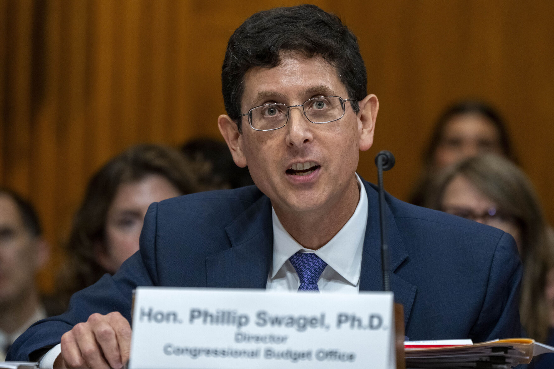 FILE - Phillip Swagel, Director of the Congressional Budget Office, testifies during a Senate Budget Committee hearing about Social Security, July 12, 2023, on Capitol Hill in Washington. The Congressional Budget Office said Friday, Dec. 15, that it expects inflation to nearly hit the Federal Reserve