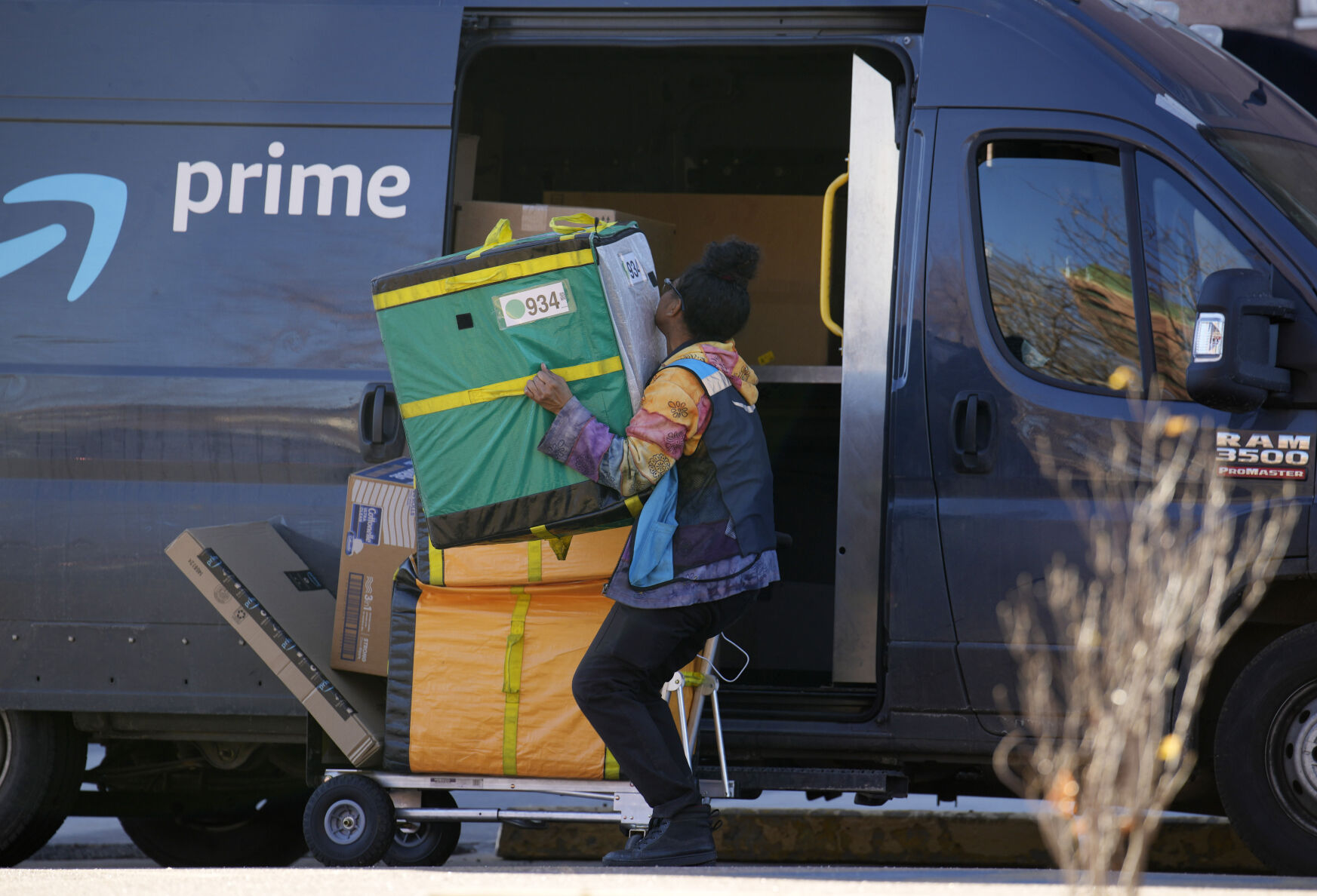 <p>An Amazon Prime delivery person lifts packages while making a stop at an apartment building on Tuesday, Nov. 28, 2023, in Denver. Walmart, Target and Amazon are all-in on the shipping wars, a move retail experts say will help them maintain a competitive edge against low-cost Chinese retailers Shein and Temu. (AP Photo/David Zalubowski)</p>   PHOTO CREDIT: David Zalubowski 