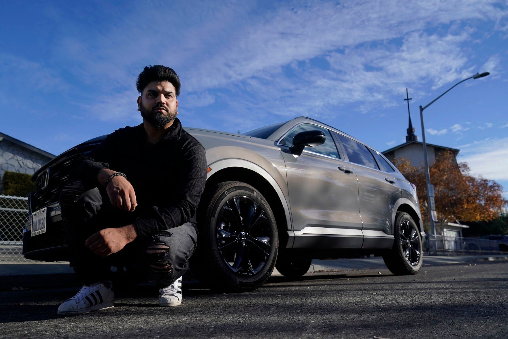 <p>Shalinder Singh poses for photos in front of a 2024 Honda CR-V Hybrid in Sunnyvale, Calif., Monday, Dec. 11, 2023. Like many hybrid buyers, Singh, an Uber driver, said that for him, the gas savings helped tip the price equation in favor of a Honda CR-V hybrid over the corresponding gasoline model. (AP Photo/Jeff Chiu)</p>   PHOTO CREDIT: Jeff Chiu 