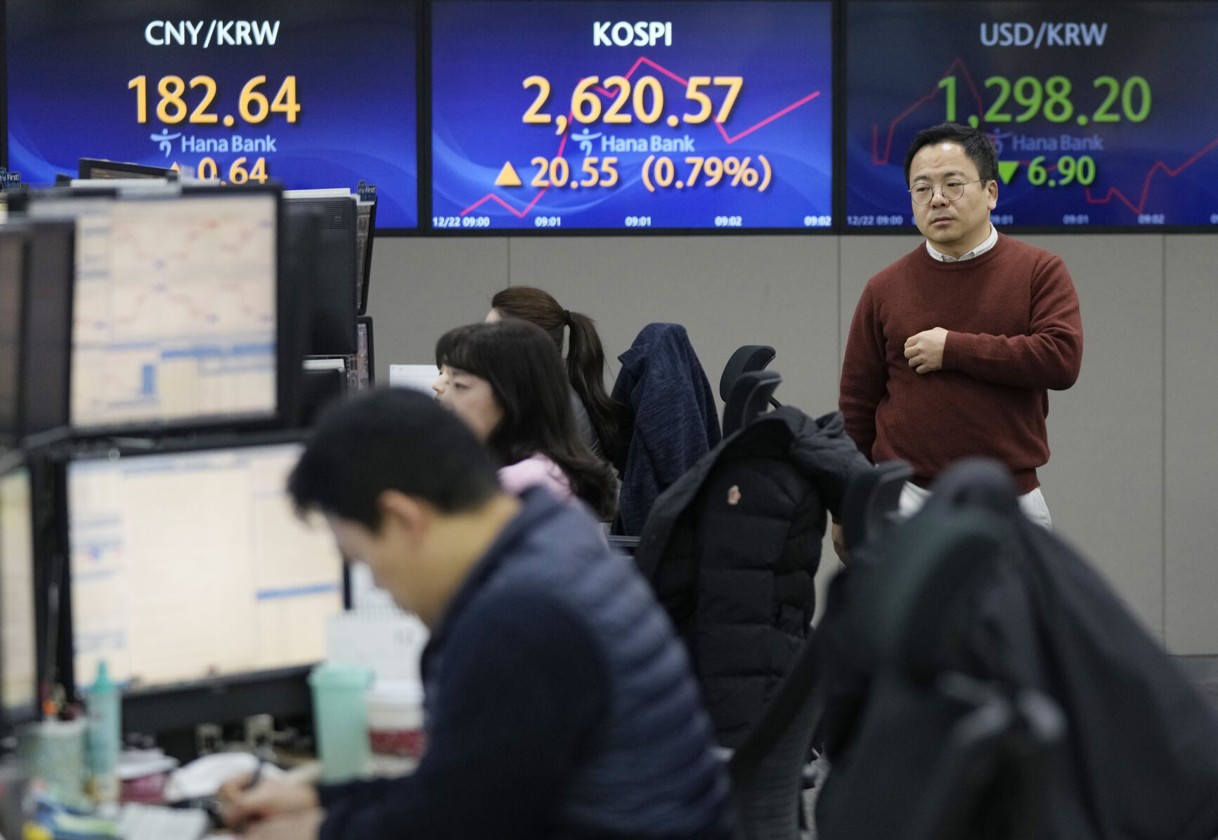 <p>A currency trader passes by the screens showing the Korea Composite Stock Price Index (KOSPI), center, and the foreign exchange rate between U.S. dollar and South Korean won, right, at the foreign exchange dealing room of the KEB Hana Bank headquarters in Seoul, South Korea, Friday, Dec. 22, 2023. Shares were mostly higher in Asia on Friday after several strong profit reports helped Wall Street claw back most of its sharp loss from day before. (AP Photo/Ahn Young-joon)</p>   PHOTO CREDIT: Ahn Young-joon - staff, ASSOCIATED PRESS