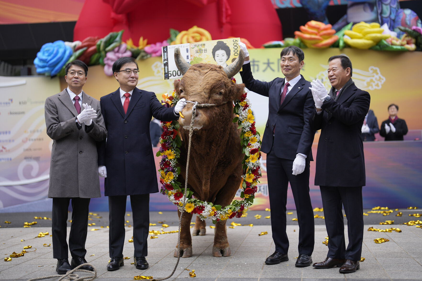 <p>South Korean financial officers pose with a bull to celebrate the opening for the Year 2024 trading outside of the Korea Exchange in Seoul, South Korea, Tuesday, Jan. 2, 2024. (AP Photo/Lee Jin-man)</p>   PHOTO CREDIT: Lee Jin-man - staff, ASSOCIATED PRESS