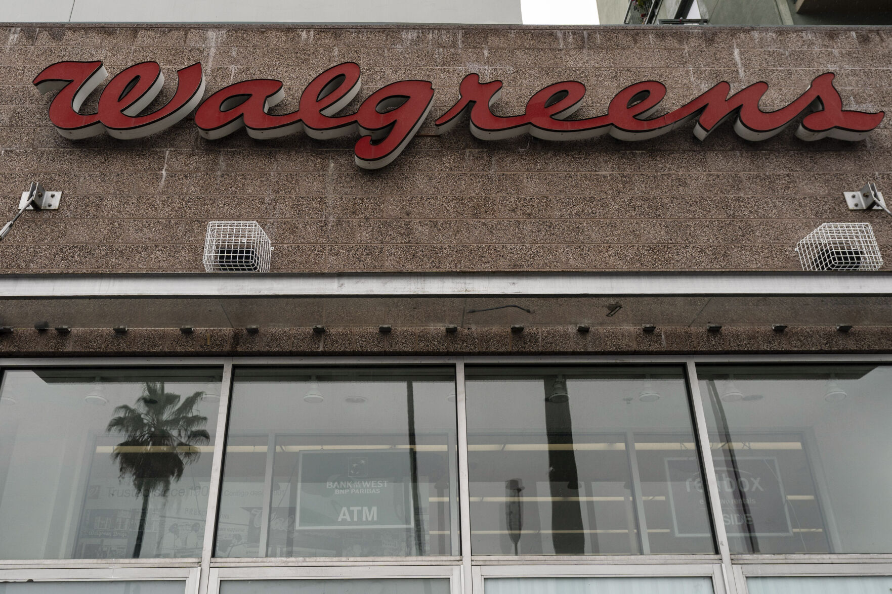 <p>A palm tree is reflected in the window of a Walgreens pharmacy in Los Angeles, Friday, March 10, 2023. Walgreens is chopping its dividend nearly in half as the drugstore chain looks to strengthen its balance sheet. The health care giant said Thursday, Jan. 4, 2024 that reducing its quarterly payout to shareholders to 25 cents per share will help free up capital to spend growing its pharmacy and health care businesses. (AP Photo/Jae C. Hong)</p>   PHOTO CREDIT: Jae C. Hong