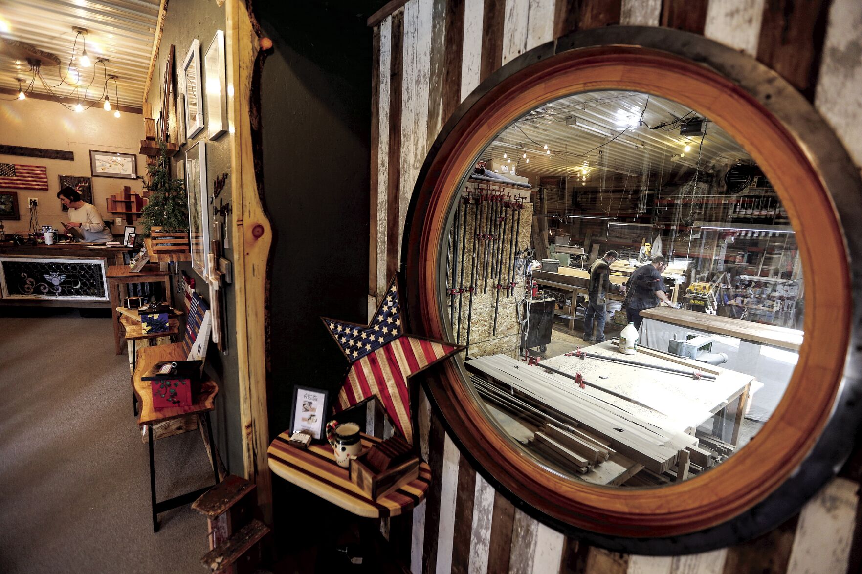 A window allows customers to take a peek into the woodworking shop of Renewed Visions — Across the Bridge in Manchester, Iowa.    PHOTO CREDIT: Dave Kettering