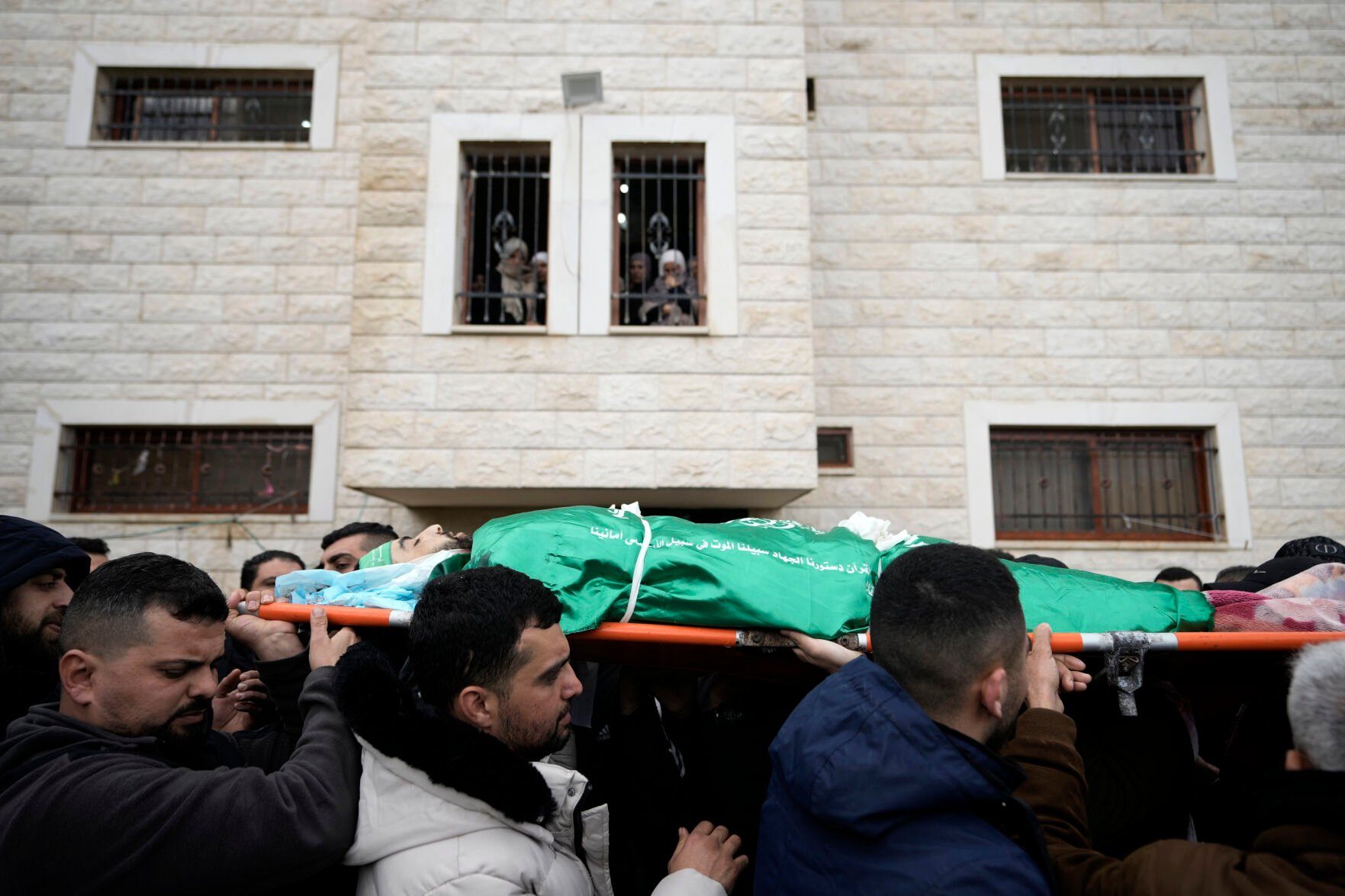 <p>Palestinian mourners carry the body of Muhammad Jalamneh, draped in the Hamas militant group flag, during his funeral after he was killed in an Israeli military raid at Ibn Sina Hospital in the West Bank town of Jenin, Tuesday, Jan. 30, 2024. Armed Israeli undercover forces disguised as women and medical workers stormed the hospital on Tuesday, killing three Palestinian militants. The Palestinian Health Ministry condemned the incursion on a hospital, where the military said the militants were hiding out.(AP Photo/Majdi Mohammed)</p>   PHOTO CREDIT: Majdi Mohammed 