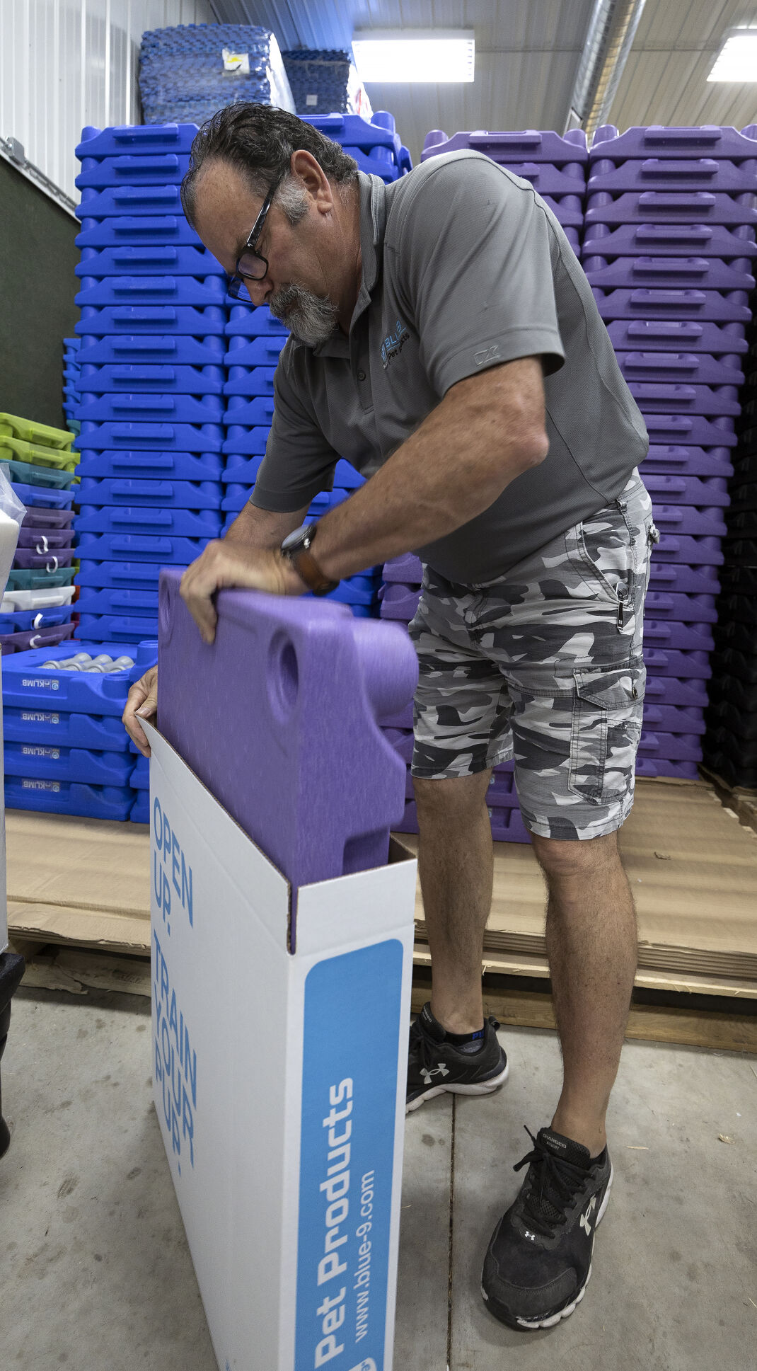 Blue-9 employee Tim Taylor loads a Klimb dog training platform into a box at the company’s warehouse.    PHOTO CREDIT: Stephen Gassman
Telegraph Herald