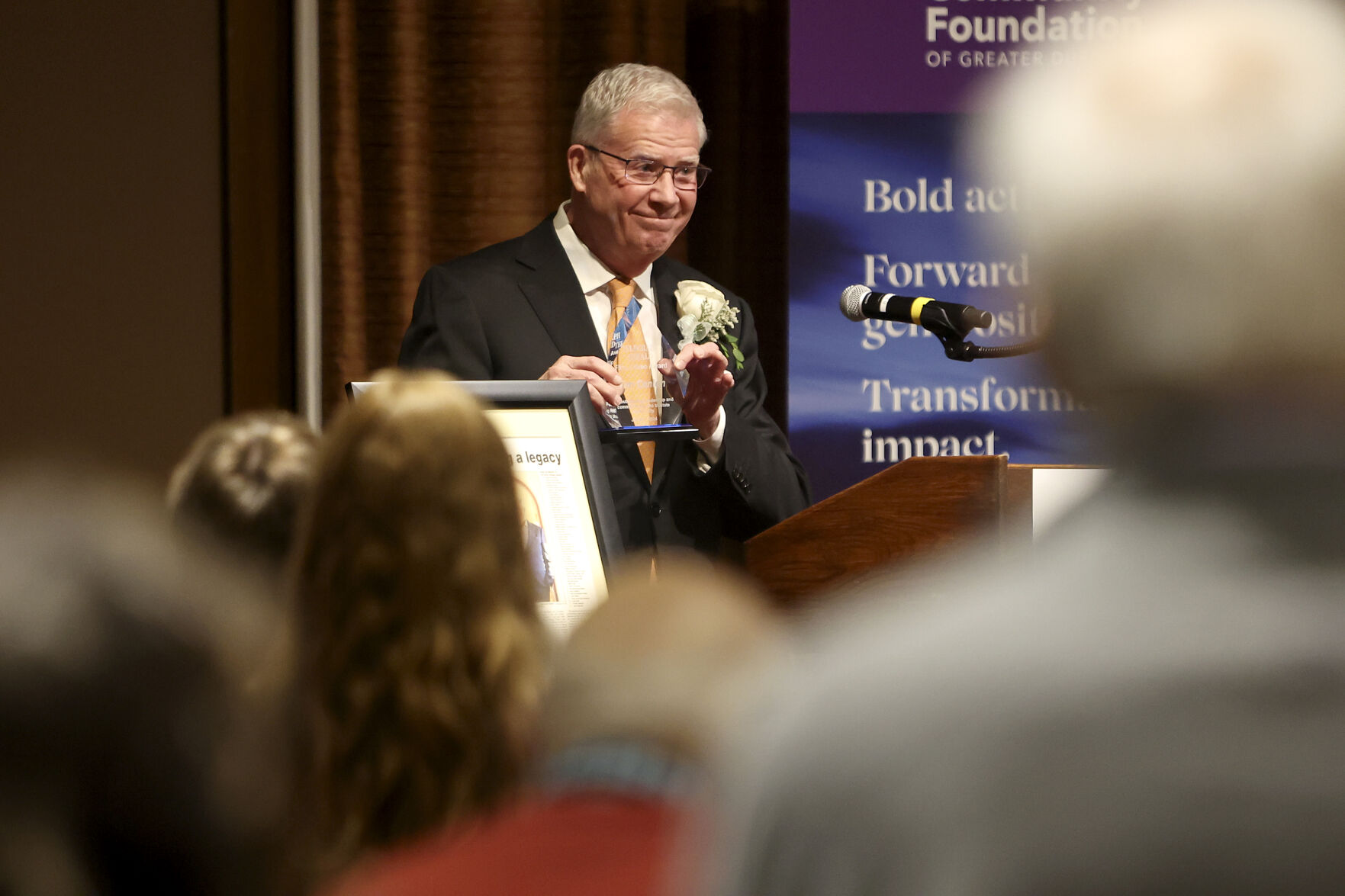Tim Conlon holds up the 2024 Telegraph Herald First Citizen Award during the reception.    PHOTO CREDIT: Dave Kettering