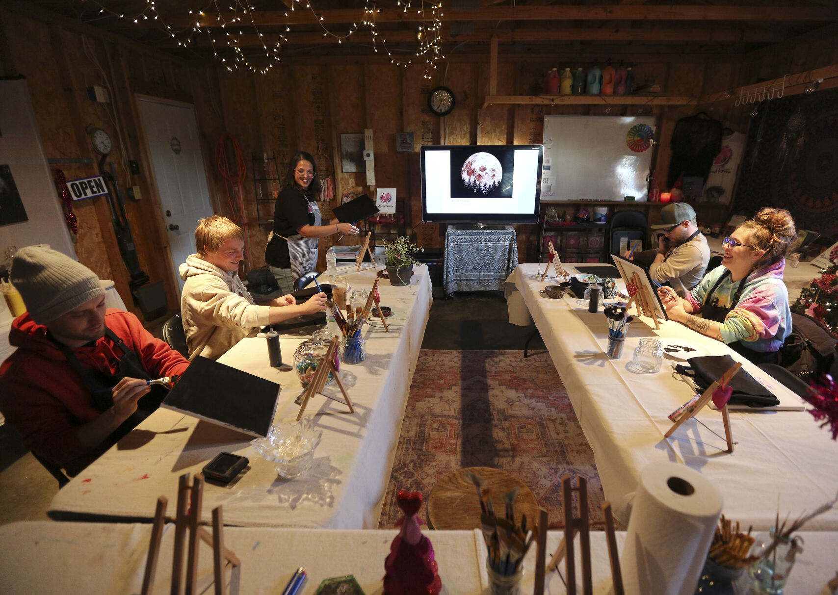 Maria Cigrand (top left), owner of The Stoned Painter, demonstrates to her students during a class in East Dubuque, Ill. The business mixes painting and cannabis for its participants.    PHOTO CREDIT: Dave Kettering
Telegraph Herald