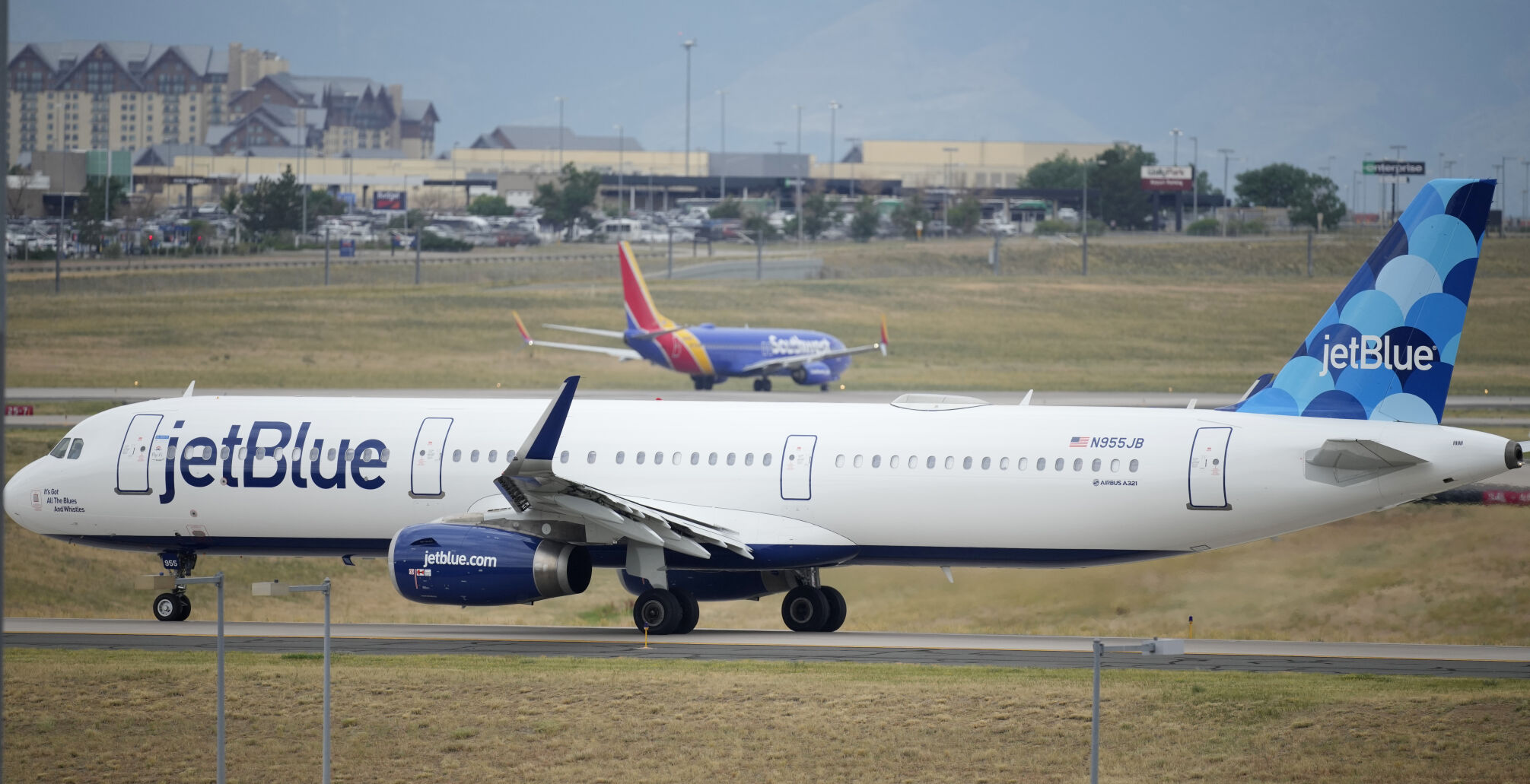 <p>FILE - A Jet Blue jetliner taxis down a runway as a Southwest Airlines airliner takes off from Denver International Airport Tuesday, July 5, 2022, in Denver. Shares of JetBlue are rising more than 15% before the market open on Tuesday, Feb. 13, 2024, as activist investor Carl Icahn took an almost 10% stake in the airline. (AP Photo/David Zalubowski, File)</p>   PHOTO CREDIT: David Zalubowski 