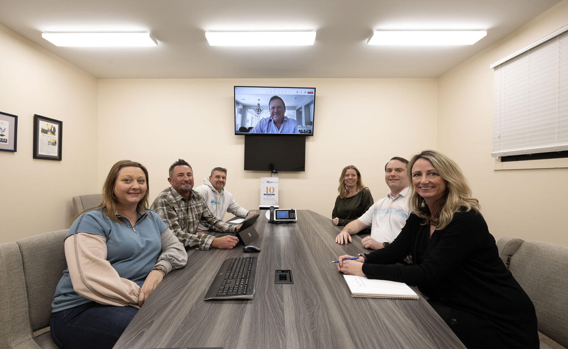 The Tri-Tech management team (from left): Jill Chapman-Cox, production manager; Greg Cox, chief operating officer; Brett Stoffel, director of customer service; Paul Acton (on screen), chief executive officer; Amber Earles, director of project management; Will Livesay, business technology consultant; and Kathryn Lyness, marketing manager. Tri-Tech is celebrating 40 years in business this year.    PHOTO CREDIT: Stephen Gassman
Telegraph Herald