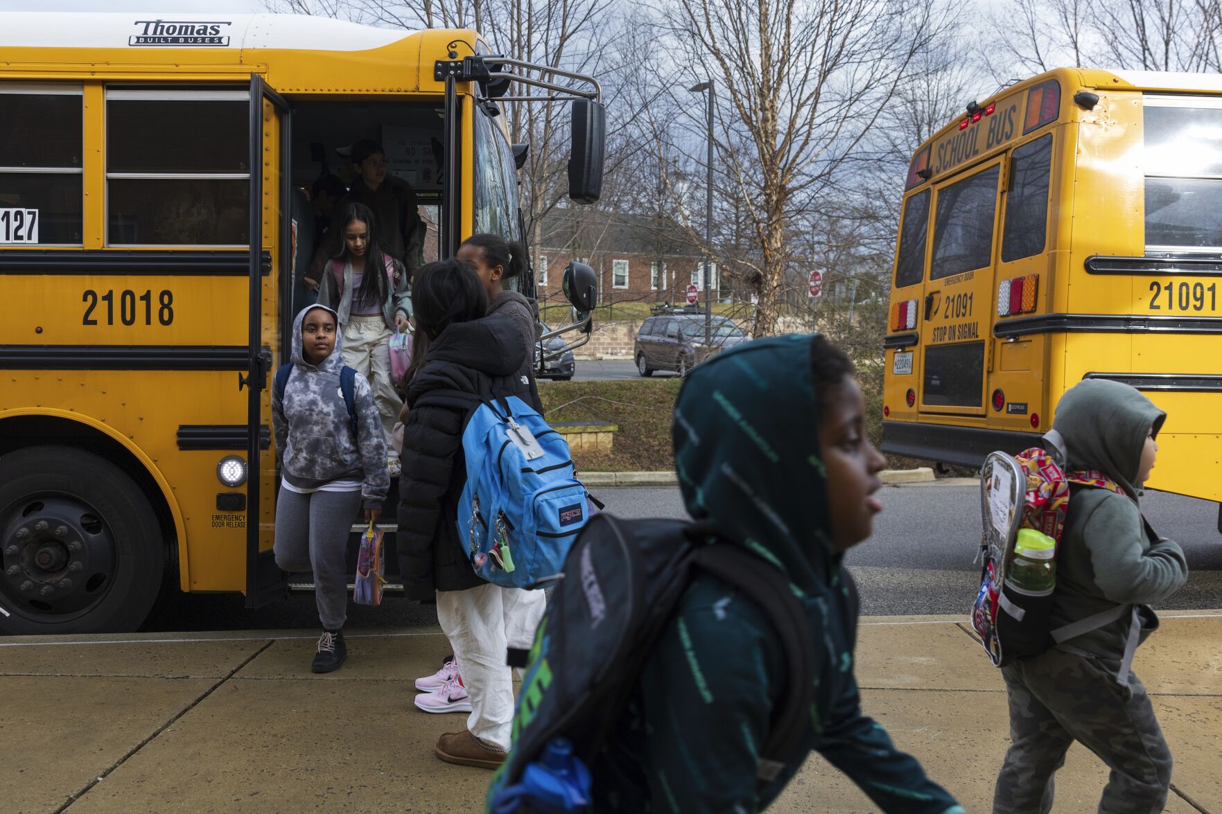 <p>Rock Creek Forest Elementary School students exit a diesel bus before attending school, Friday, Feb. 2, 2024, in Chevy Chase, Md. At right is an electric school bus. (AP Photo/Tom Brenner)</p>   PHOTO CREDIT: Tom Brenner 