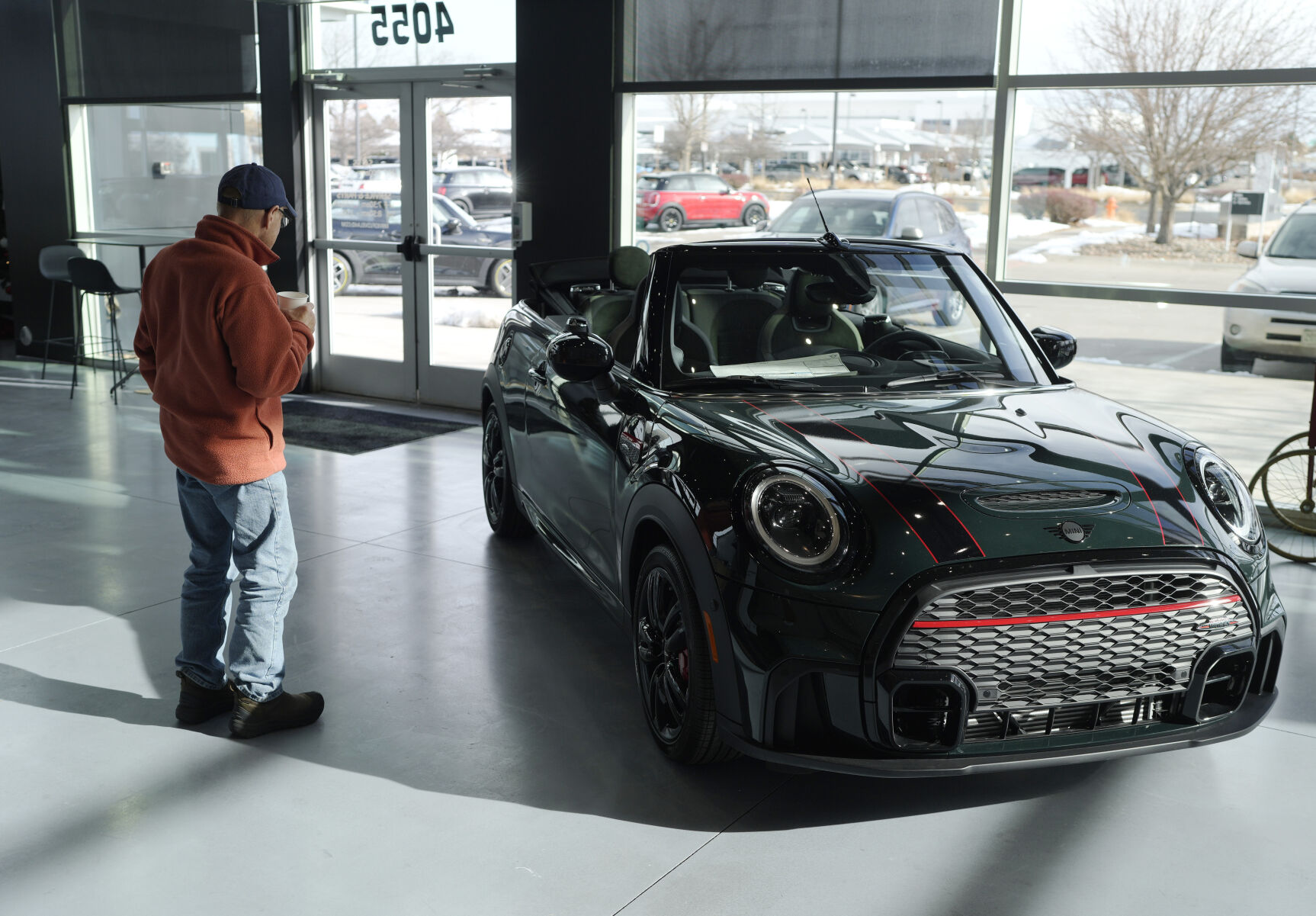 <p>FILE - A man looks at a 2024 Cooper S John Cooper Works convertible at a Mini dealership on Nov. 30, 2023, in Loveland, Colo. Automobile prices, which had been fueling inflation in the U.S., are starting to drop, helping to slow overall consumer price increases and giving buyers hope of getting a deal. (AP Photo/David Zalubowski, File)</p>   PHOTO CREDIT: David Zalubowski