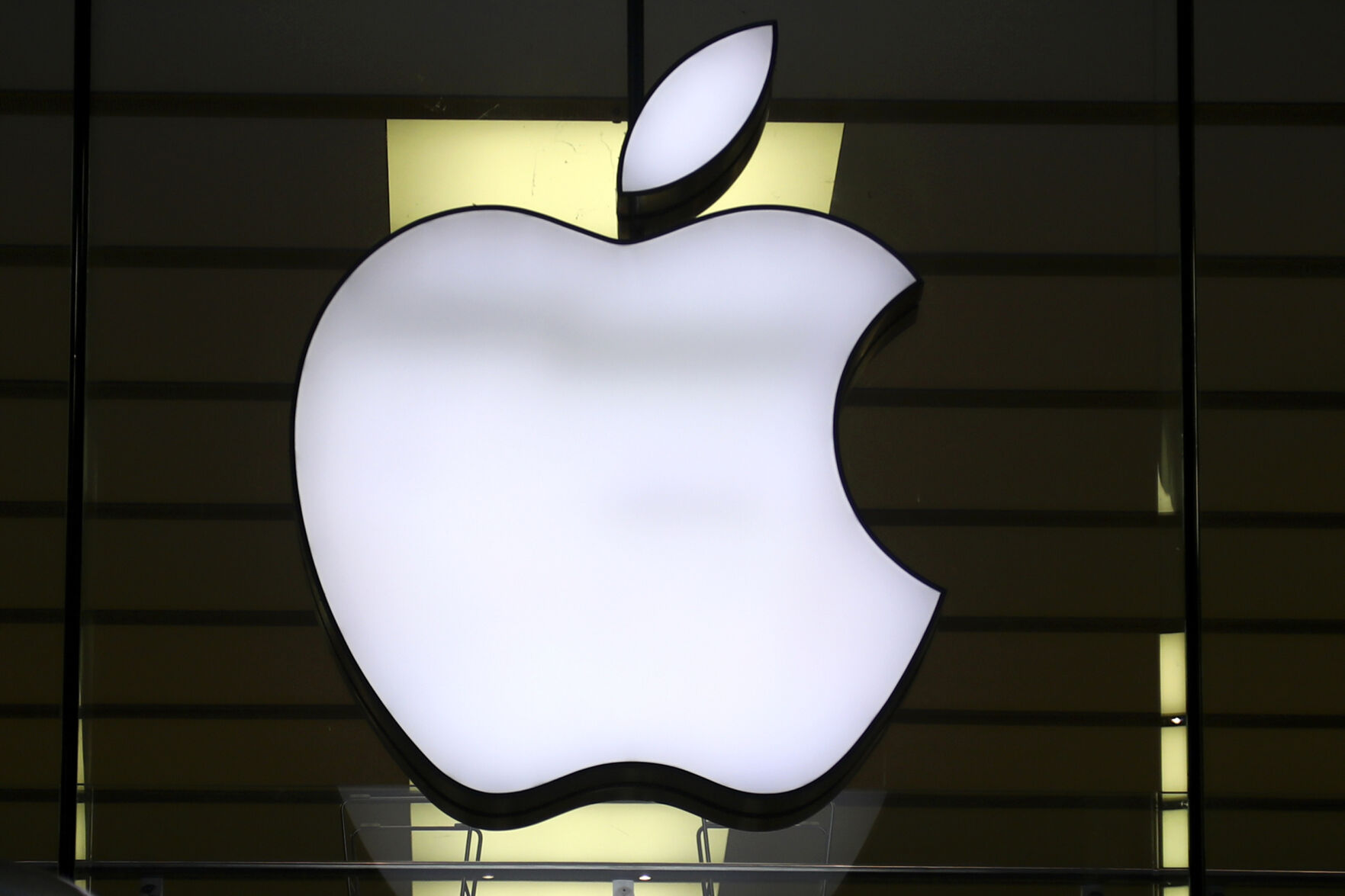<p>FILE - The Apple logo is illuminated at a store in the city center of Munich, Germany, Dec. 16, 2020. European Union fines Apple nearly $2 billion for unfairly favoring its own music streaming service over rivals. (AP Photo/Matthias Schrader, File)</p>   PHOTO CREDIT: Matthias Schrader