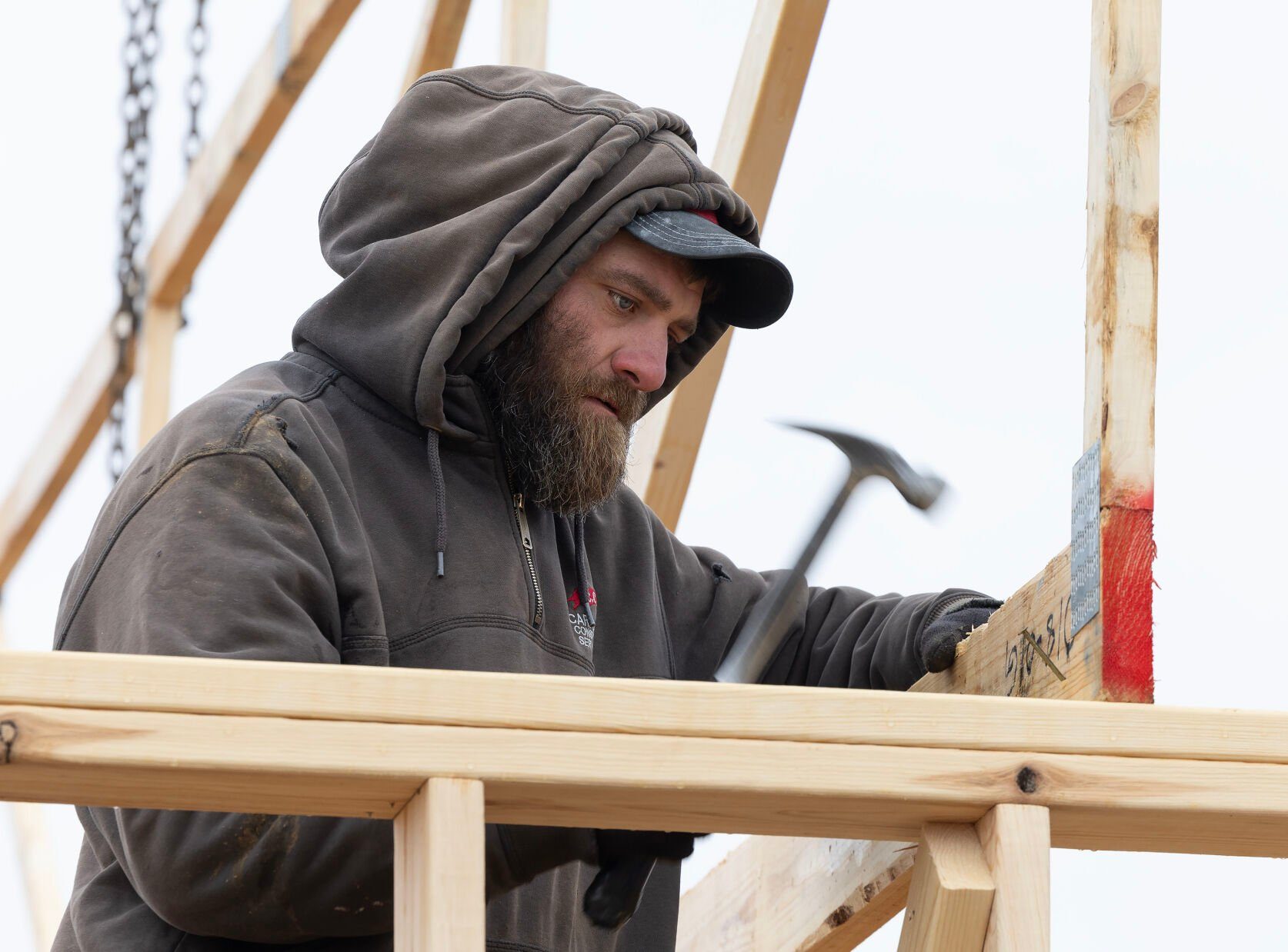 Nate Lange, with Carpenters Construction Services Inc., sets a roof joist into place at a home in Kieler, Wis.    PHOTO CREDIT: Stephen Gassman
Telegraph Herald