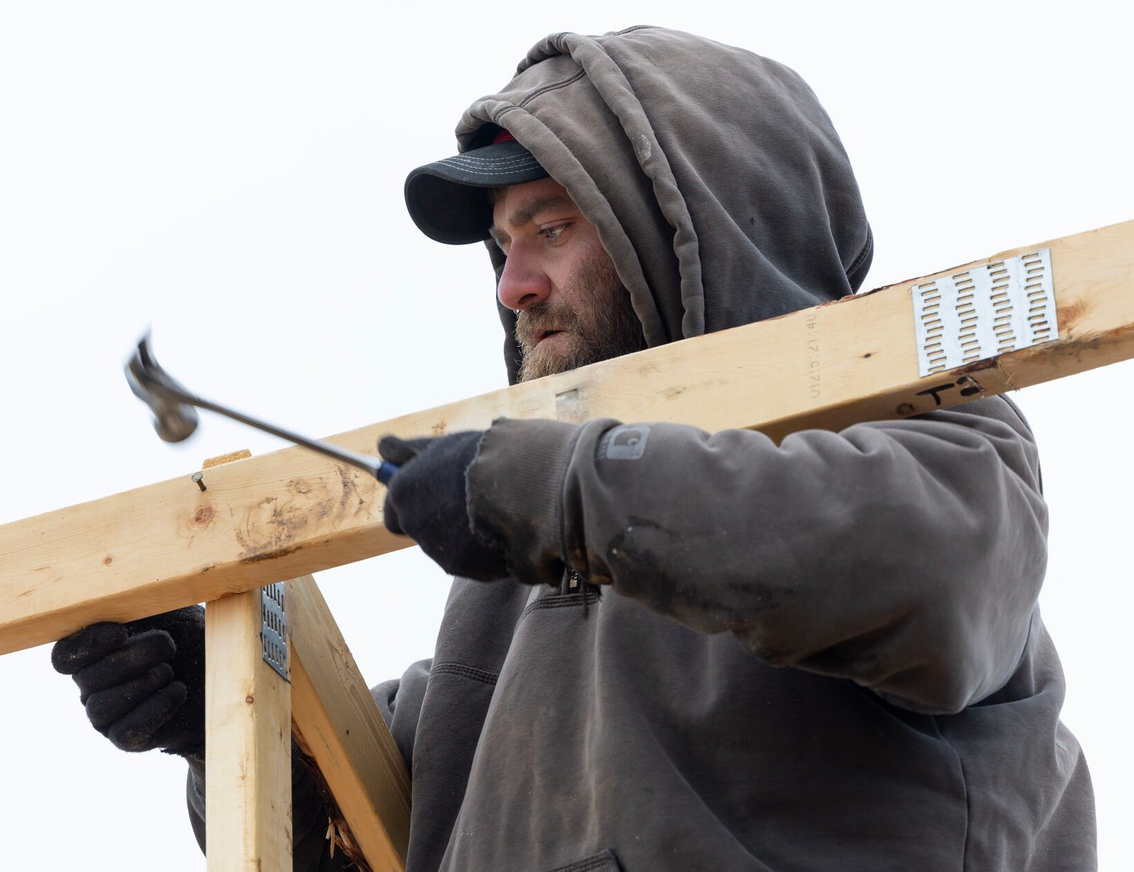 Nate Lange, with Carpenters Construction Services Inc., sets a roof joist into place at a home in Kieler, Wis.    PHOTO CREDIT: Stephen Gassman
Telegraph Herald