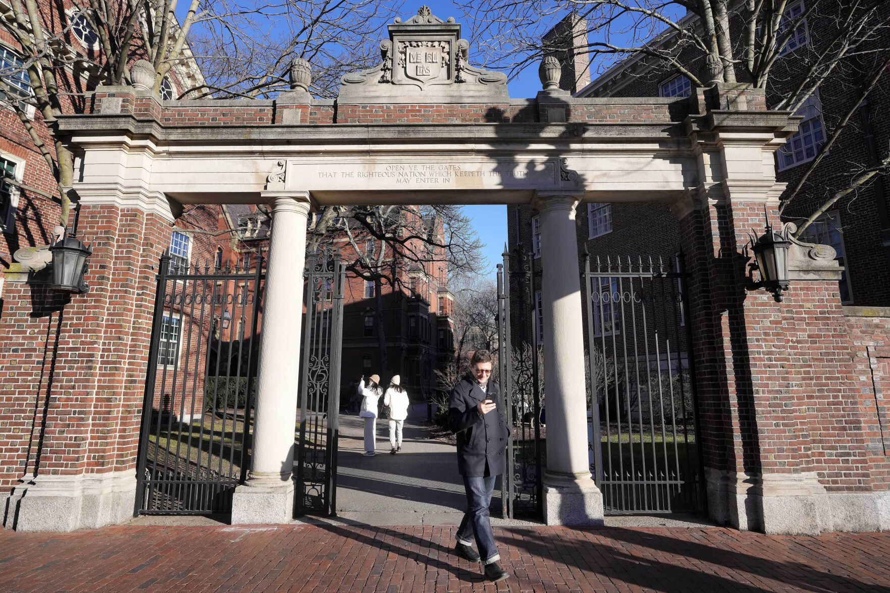 <p>CORRECTS DOLLAR AMOUNT FROM $90,000 TO $95,000 - FILE - A passer-by walks through a gate to the Harvard University campus, Jan. 2, 2024, in Cambridge, Mass. As more than 2 million graduating high school students from across the United States finalize their decisions on what college to attend this fall, many are facing jaw-dropping costs — in some cases, as much as $95,000. (AP Photo/Steven Senne, File)</p>   PHOTO CREDIT: Steven Senne